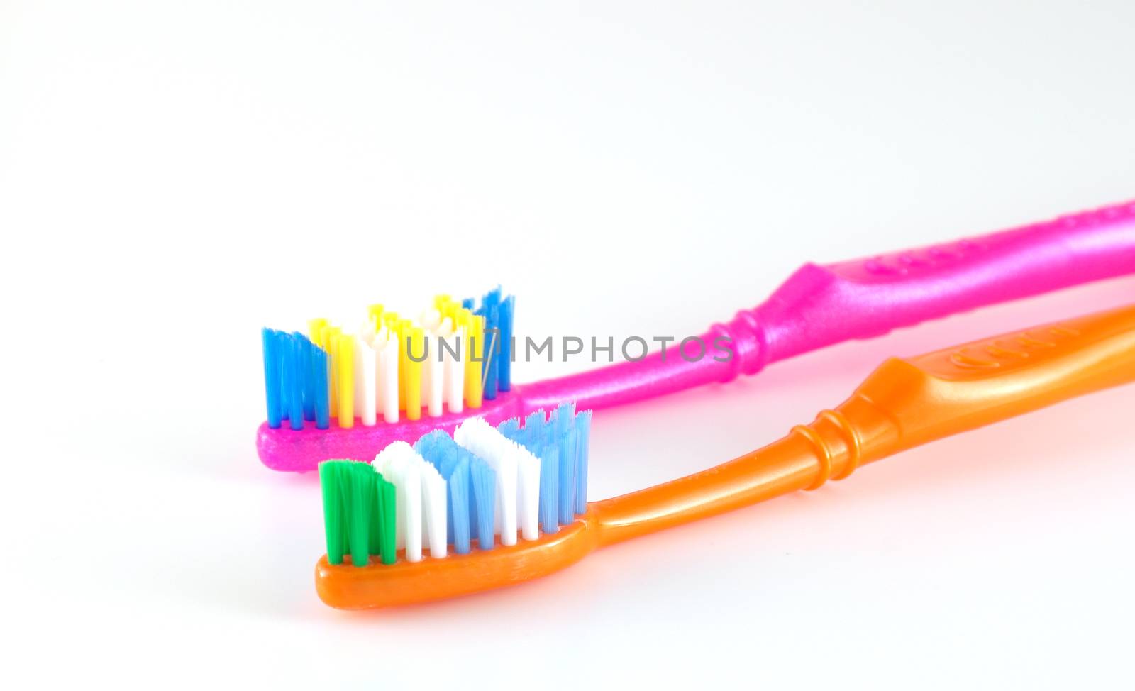 Two tooth-brushes over white, shallow DOF