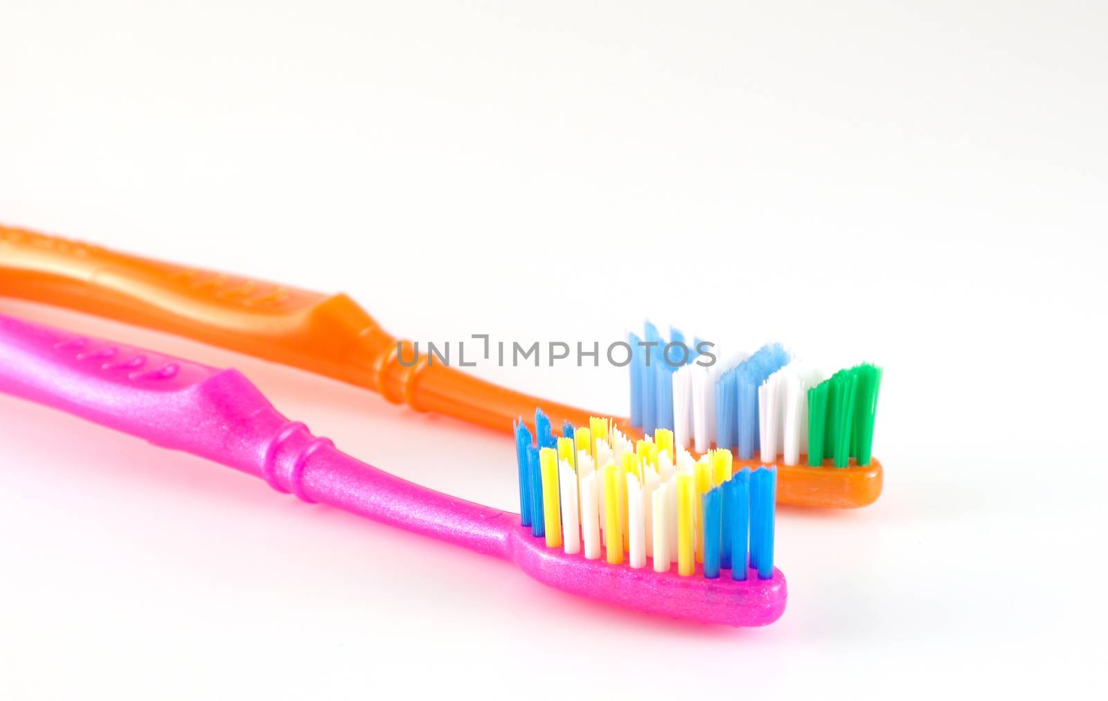 Two tooth-brushes over white