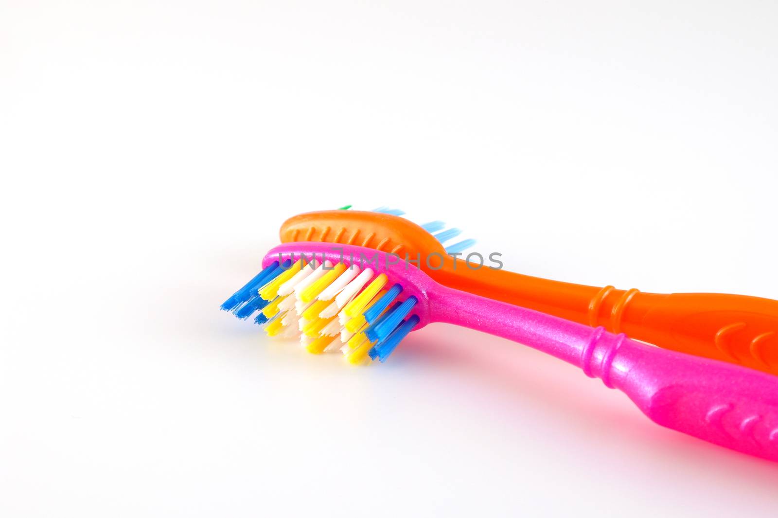 Two tooth-brushes over white. Shallow DOF