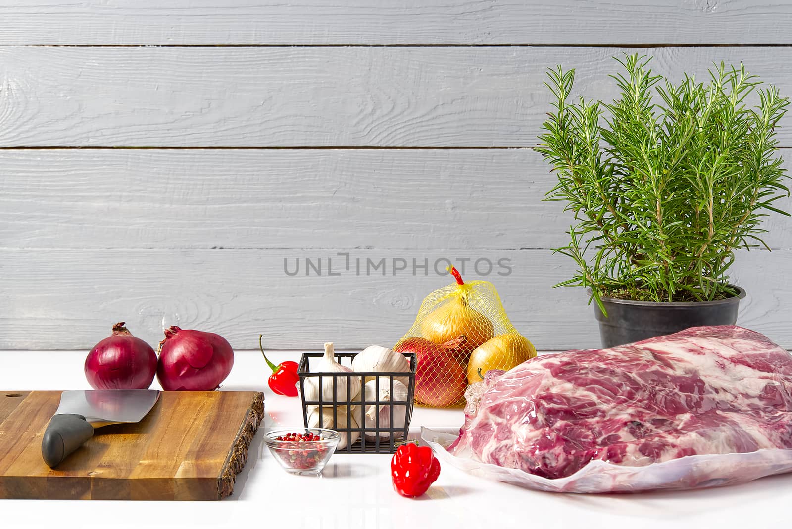 Raw pork neck on white table with vegetables