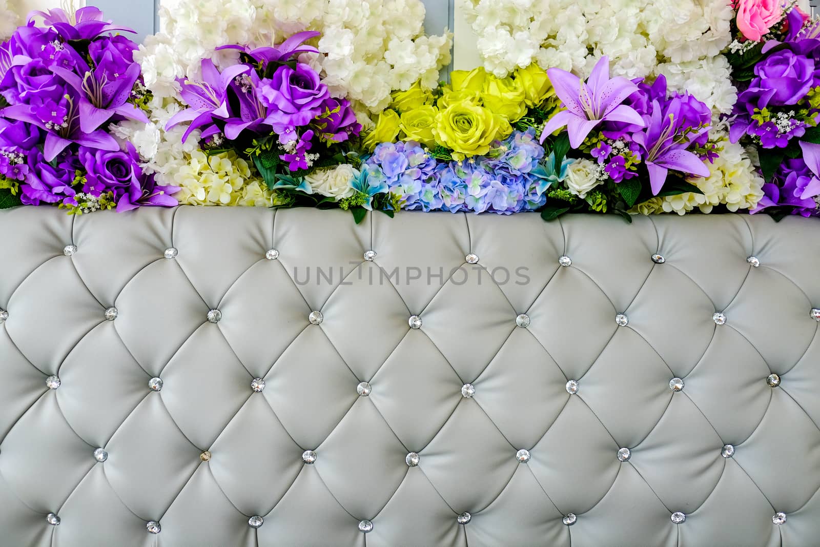 gray leather upholstery and artificial flowers background