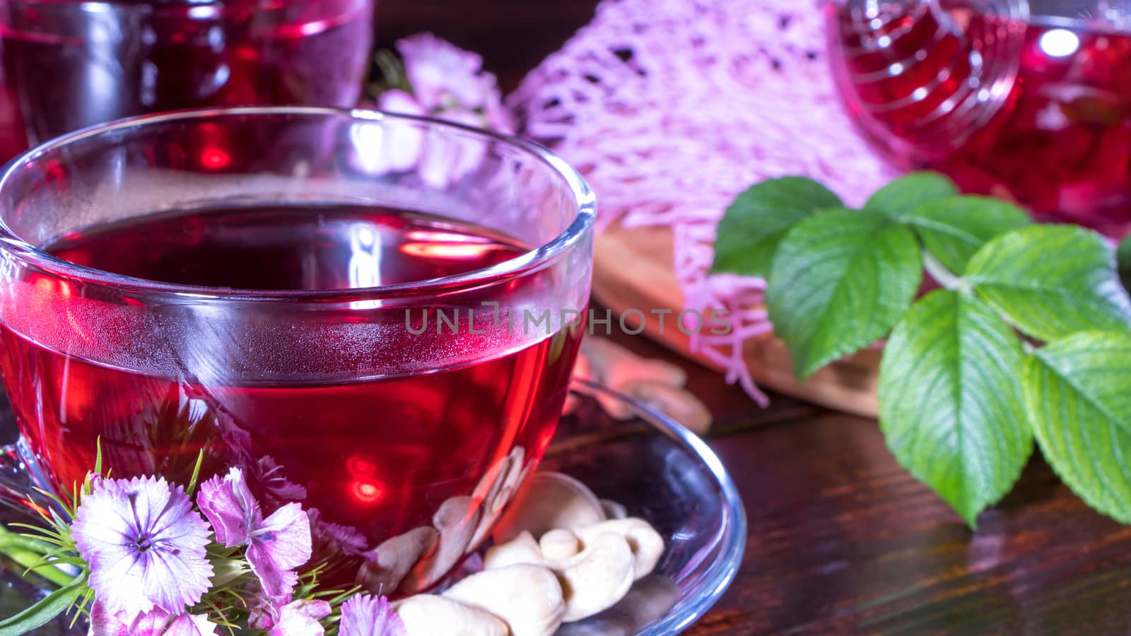 A mug of red tea in white hibiscus flowers and green leaves of m by YevgeniySam