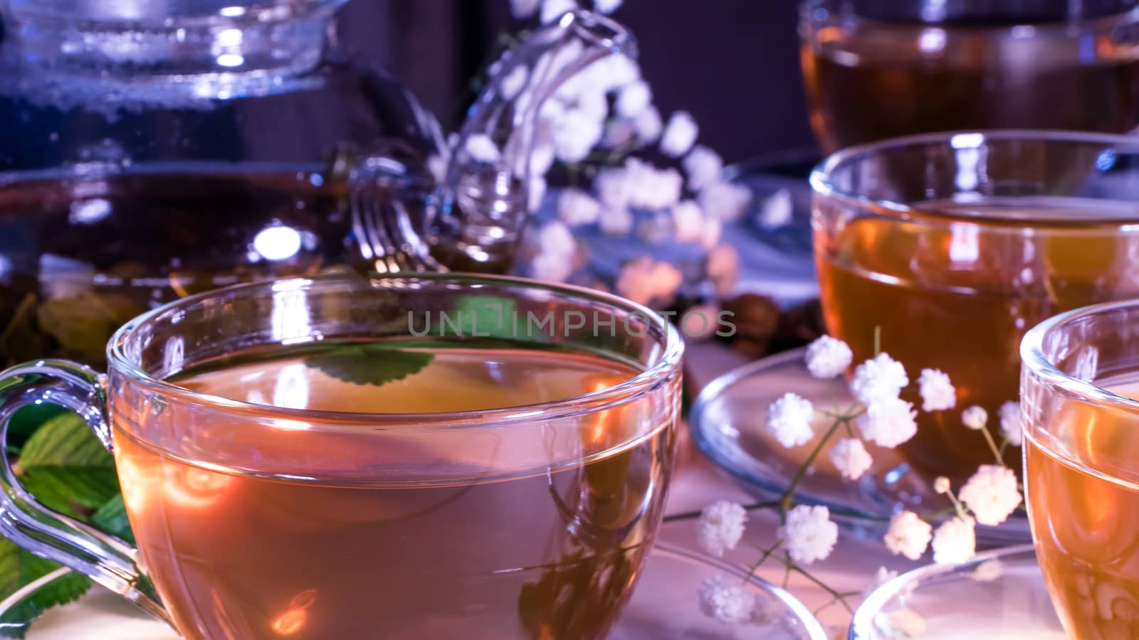 Teapot and mugs with green tea, cashew nuts, green leaves and white gypsophila flowers.Tea ceremony, traditional drink. Afternoon tea, homelike. Oriental, cozy, preparation, japanese, leafy, herbal