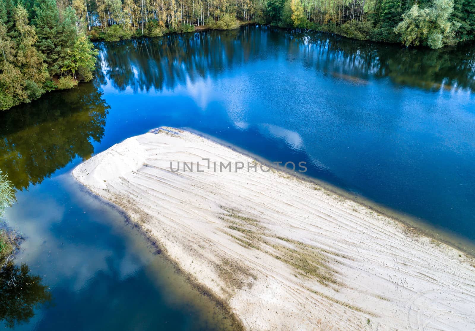 Sand island in a lake from a sand quarry, aerial view with the drone