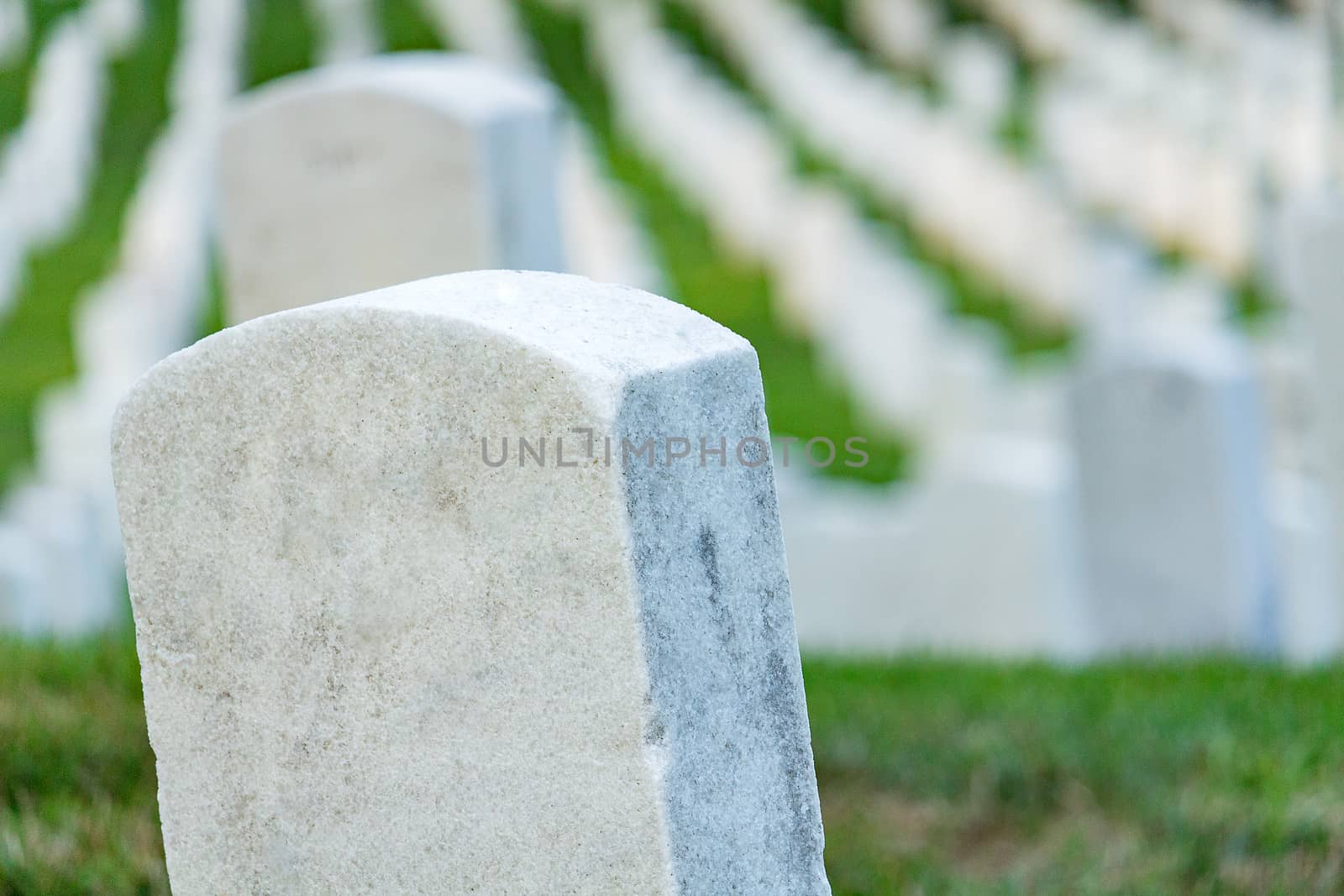 Grave stones on a peaceful cemetery, selective focus on a front stone.