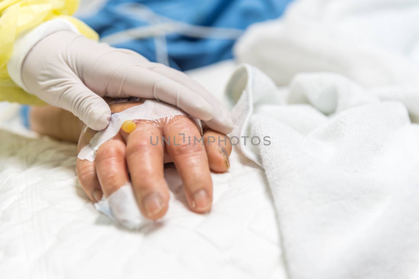 Patient in the hospital with saline intravenous and relatives patient hand holding a elderly patient hand