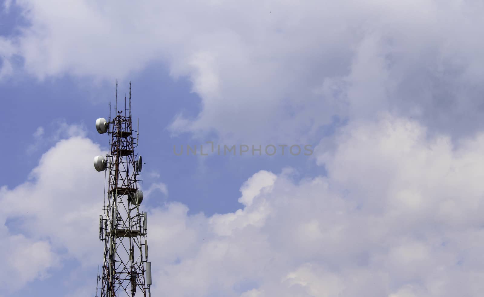 Electronic signal pole with cloud and blue sky background.