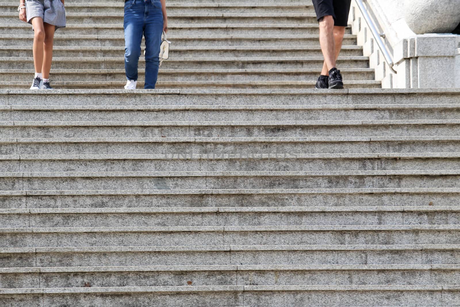 People walking down on concrete stairs in the park.