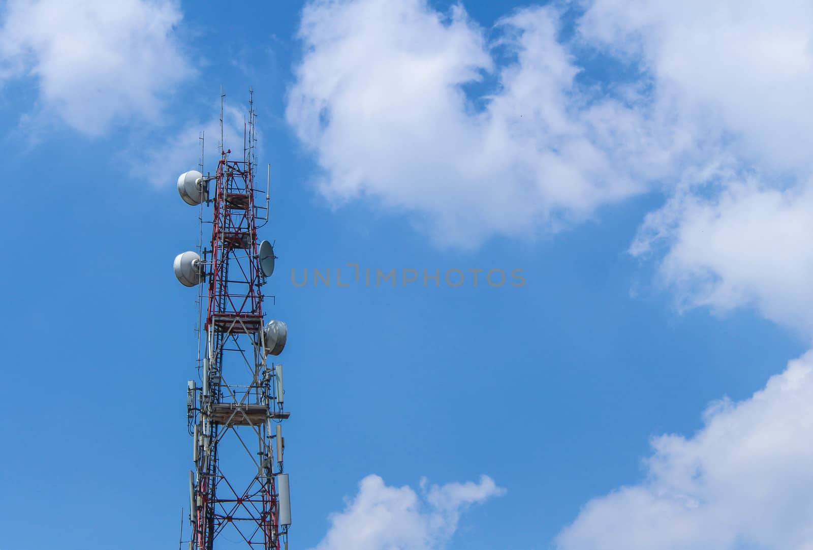 Electronic signal pole with cloud and blue sky background.