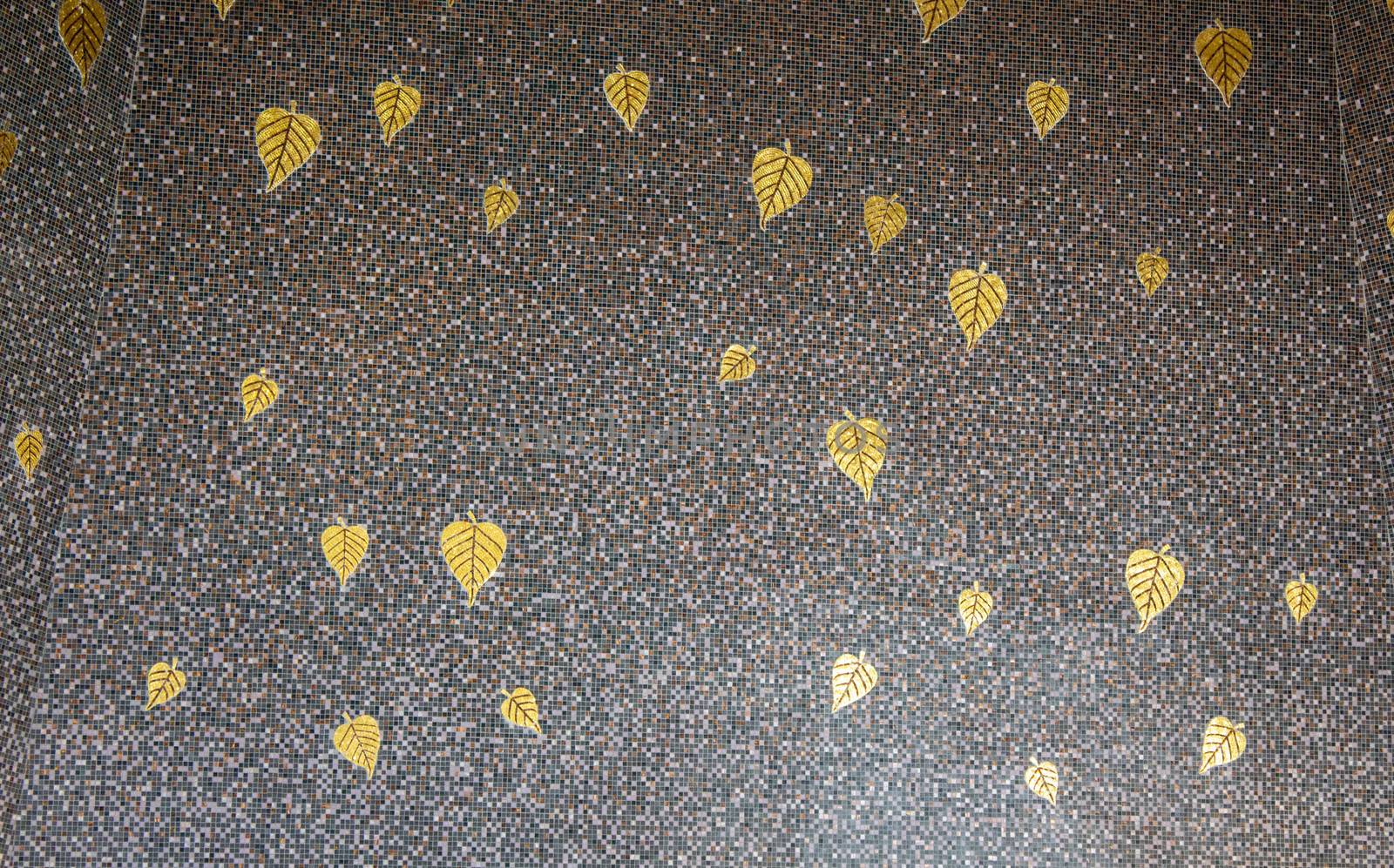 Gray marble patterned tiles decorated with golden Bodhi leaves.