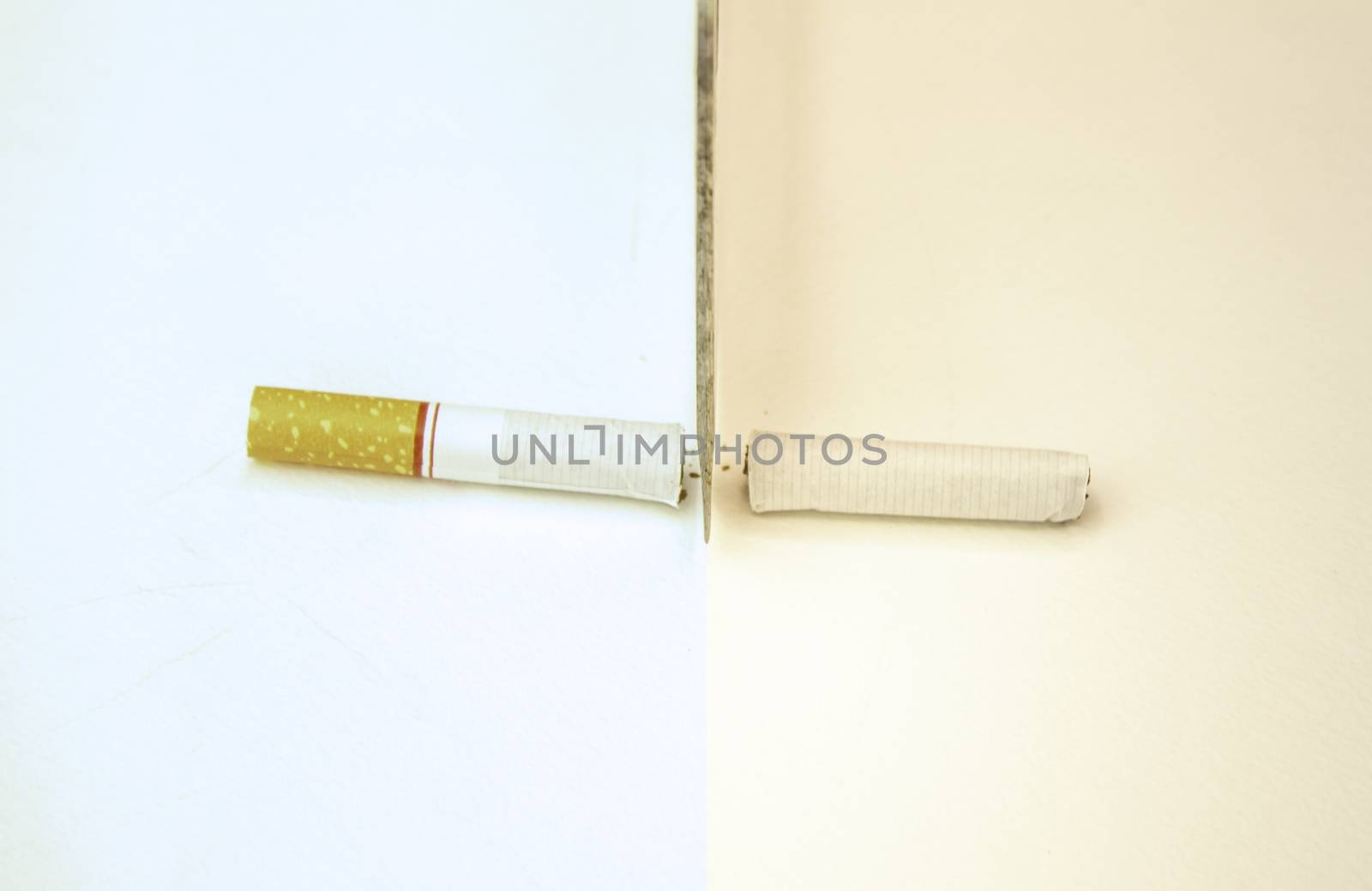 World No Tobacco Day; Use a knife to cut cigarettes isolated on white background. Cigarette destruction concept. by TEERASAK