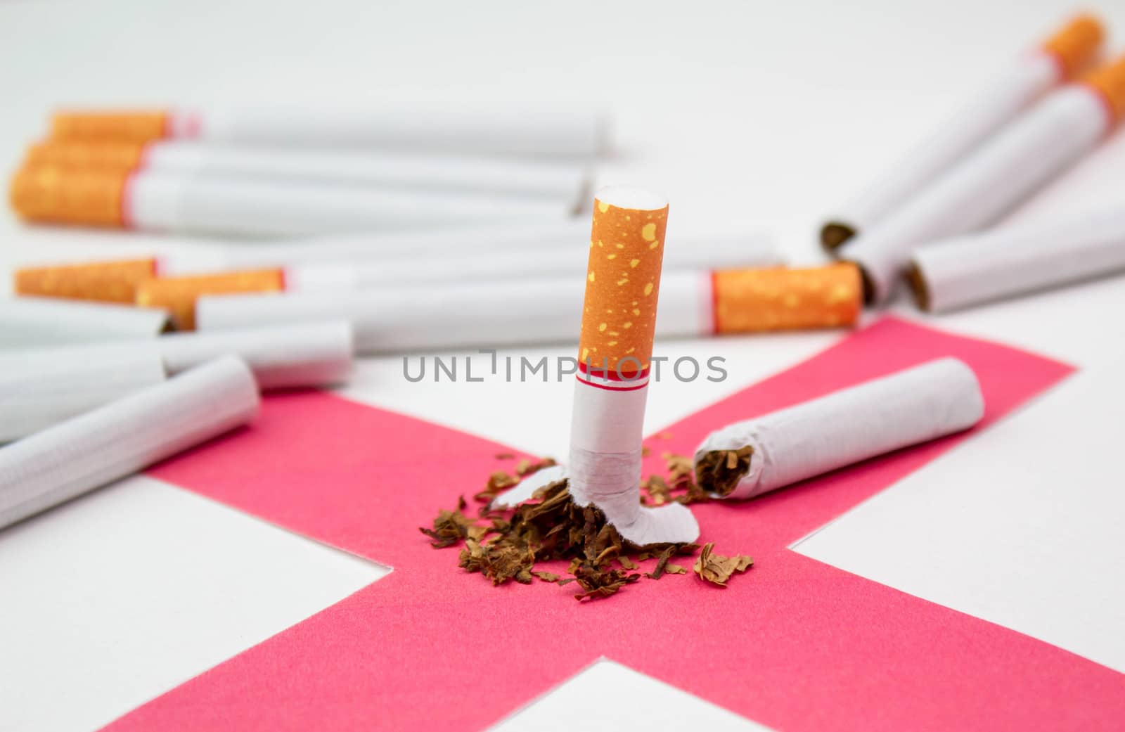 World No Tobacco Day; Broken cigarette on red cross with many Cigarettes on white background. by TEERASAK