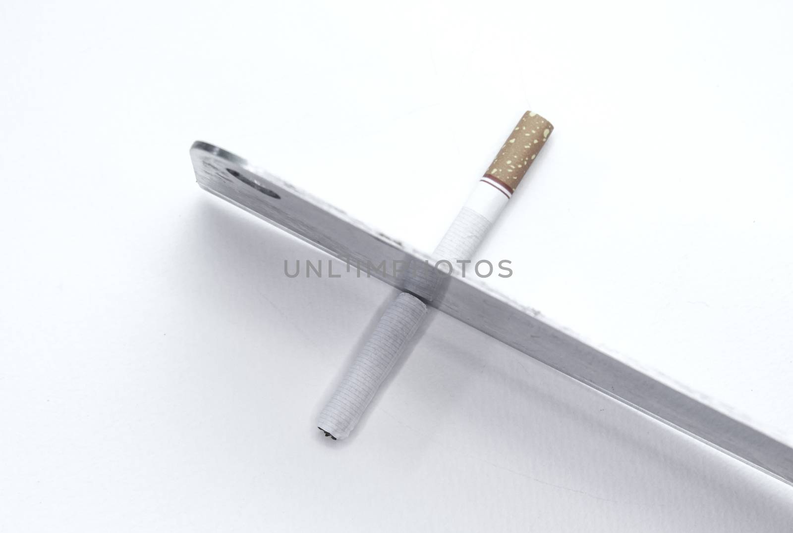 World No Tobacco Day; Use a knife to cut cigarettes isolated on white background. Cigarette destruction concept. by TEERASAK