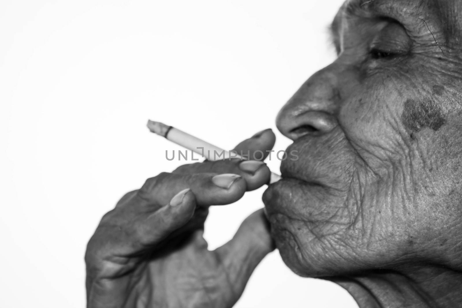 World No Tobacco Day; Elderly Asian man is smoking isolated on white background with space for idea text. by TEERASAK