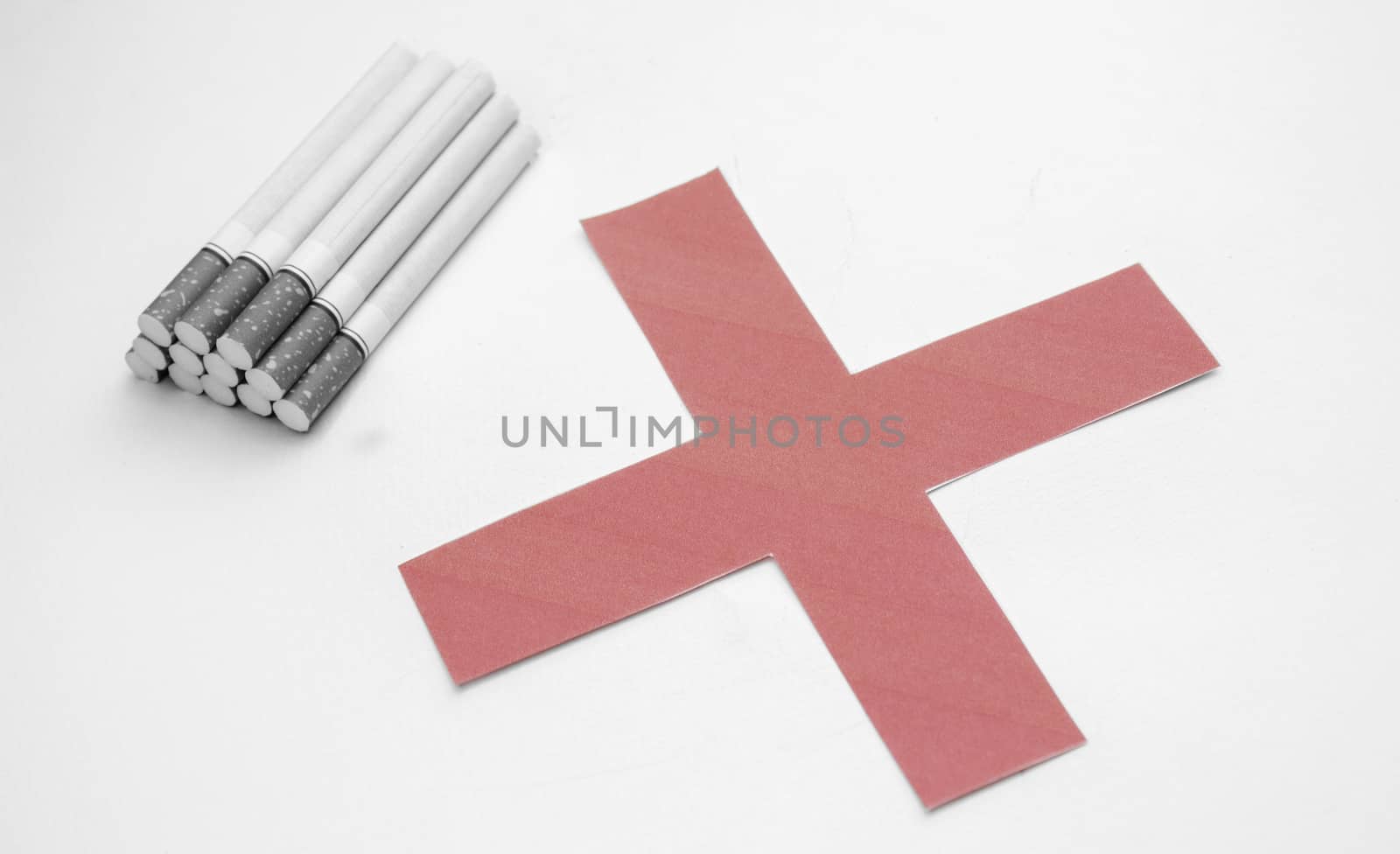 World No Tobacco Day; Heap of cigarettes with filter isolated on white background and Red cross symbol.