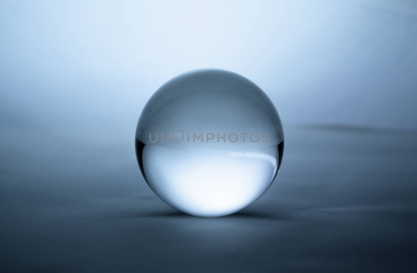 Crystal glass ball sphere transparent on green gradient background. by TEERASAK