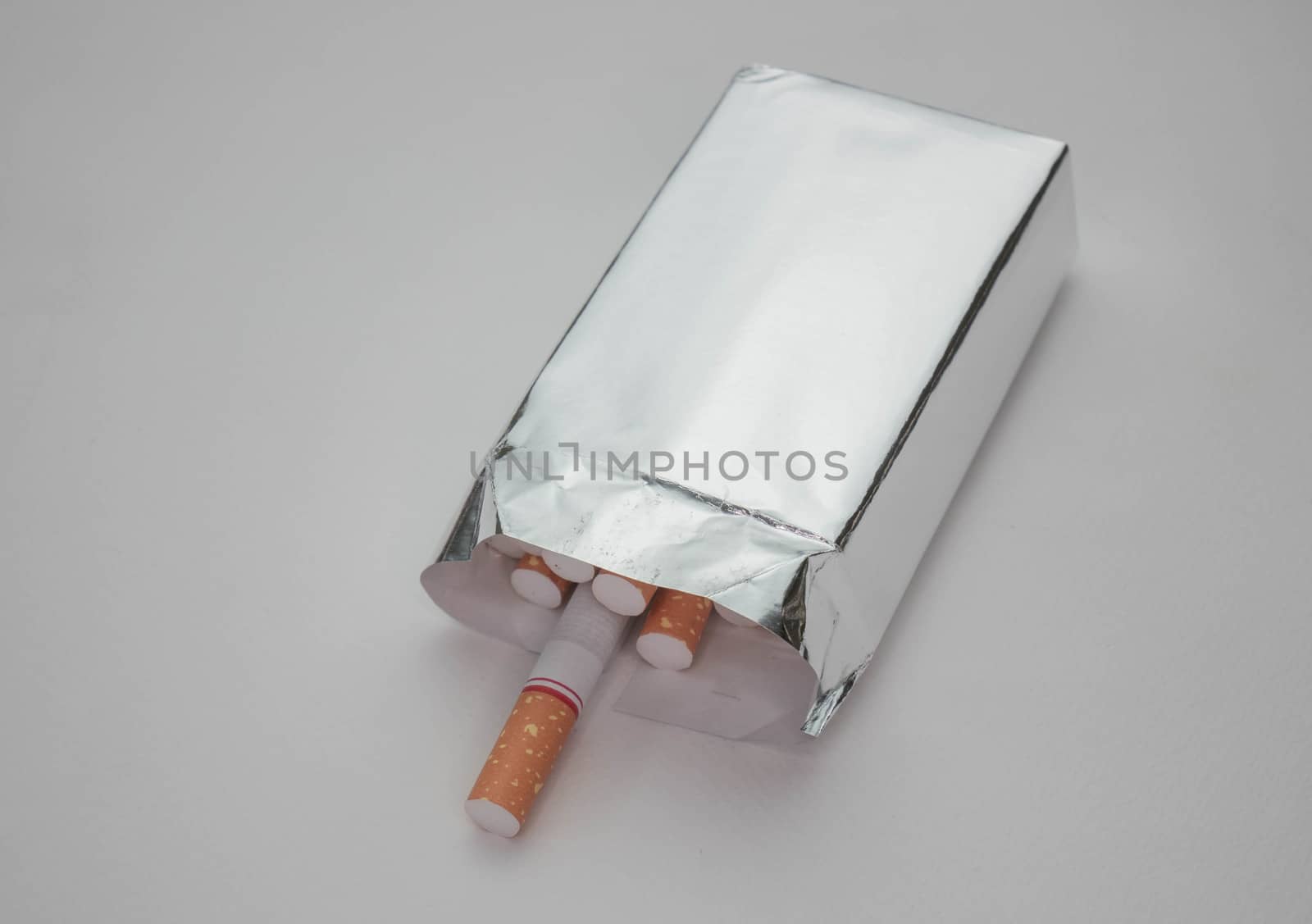 World No Tobacco Day; Open pack of cigarette tobacco in foil isolated on white background. by TEERASAK