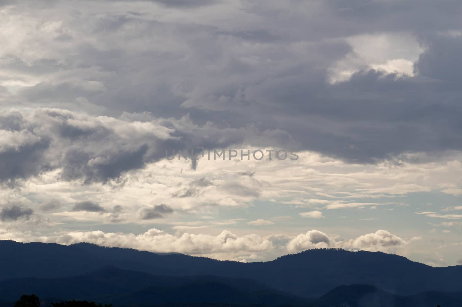 The Dark gray dramatic sky with large clouds on mountain in rainy seasons.