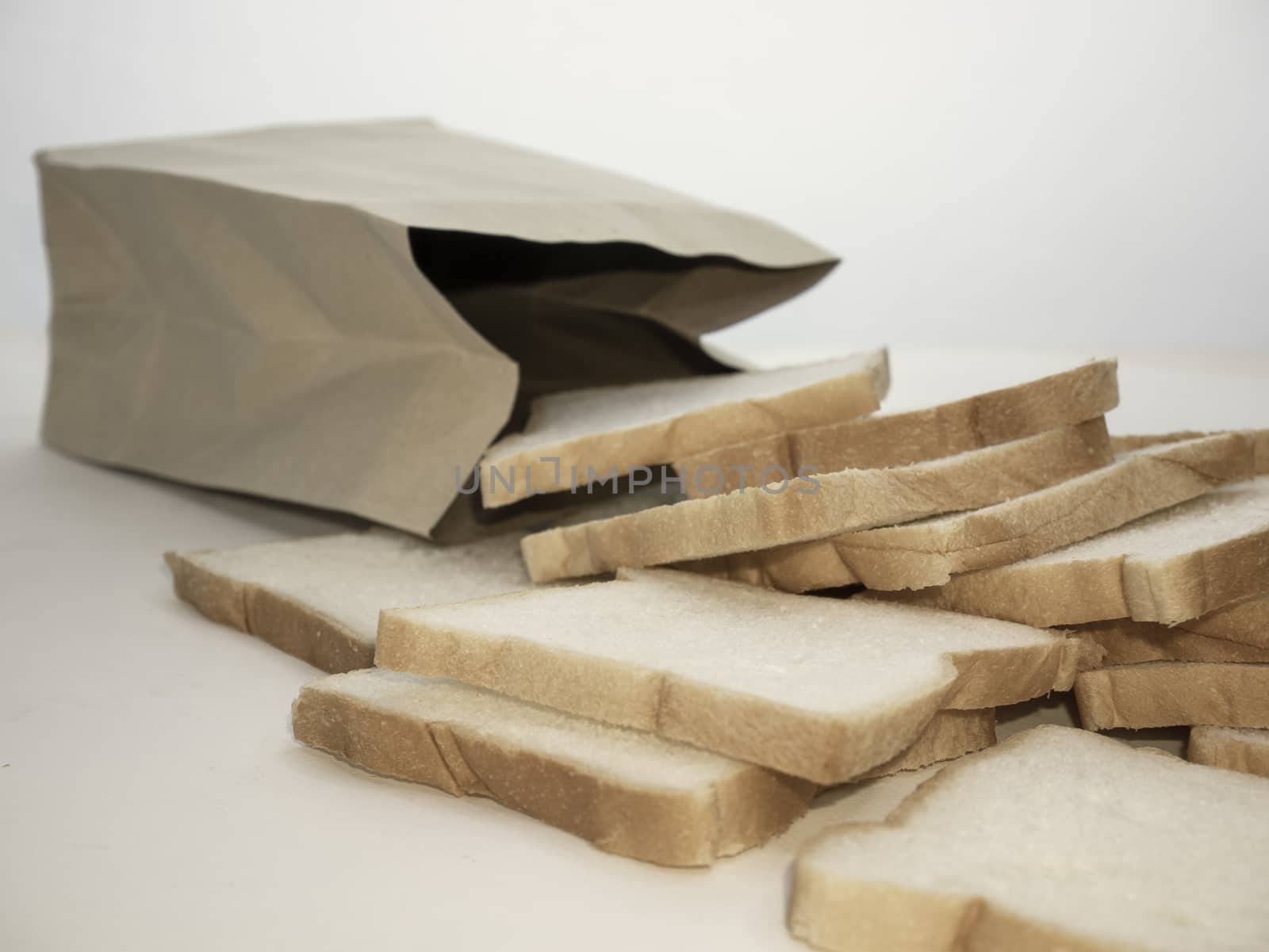 Bread full sliced in paper bag isolated on white background. by TEERASAK