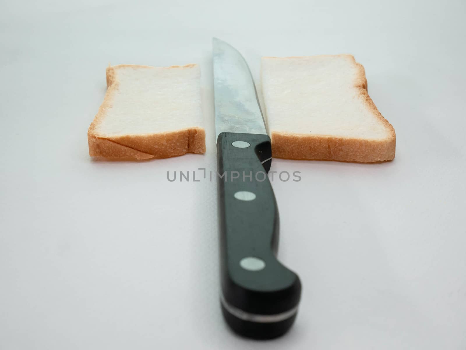 Sliced Bread with knife on white background. by TEERASAK