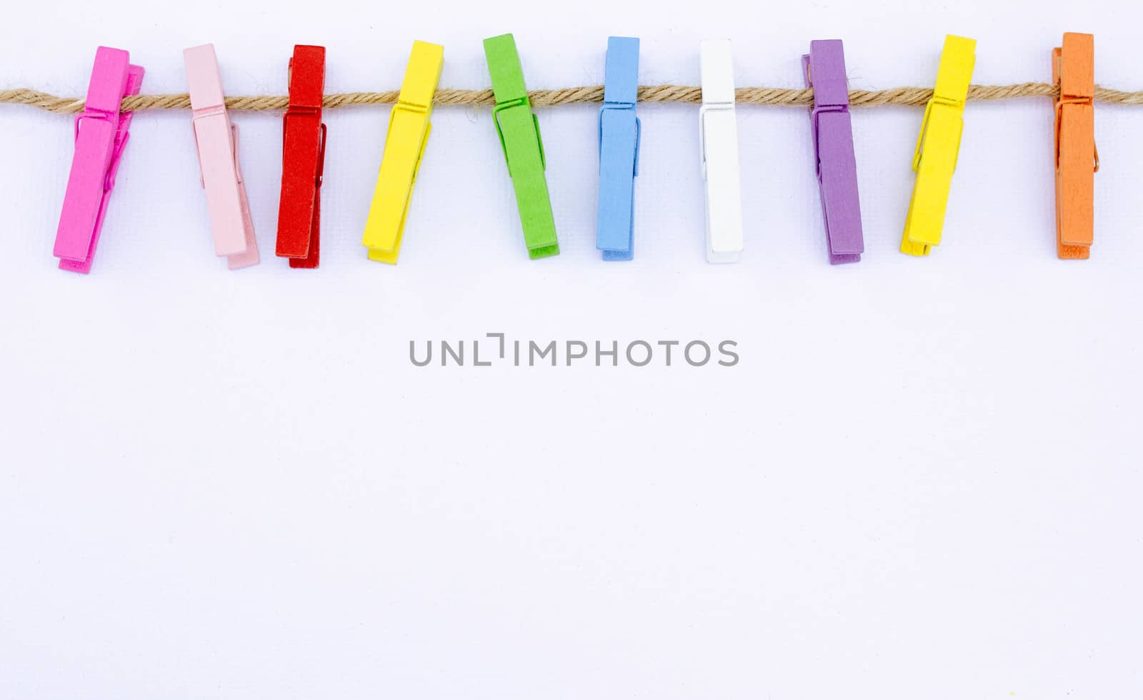 Color wooden clip on rope isolated on white background. This has clipping path. Frame and background concept.