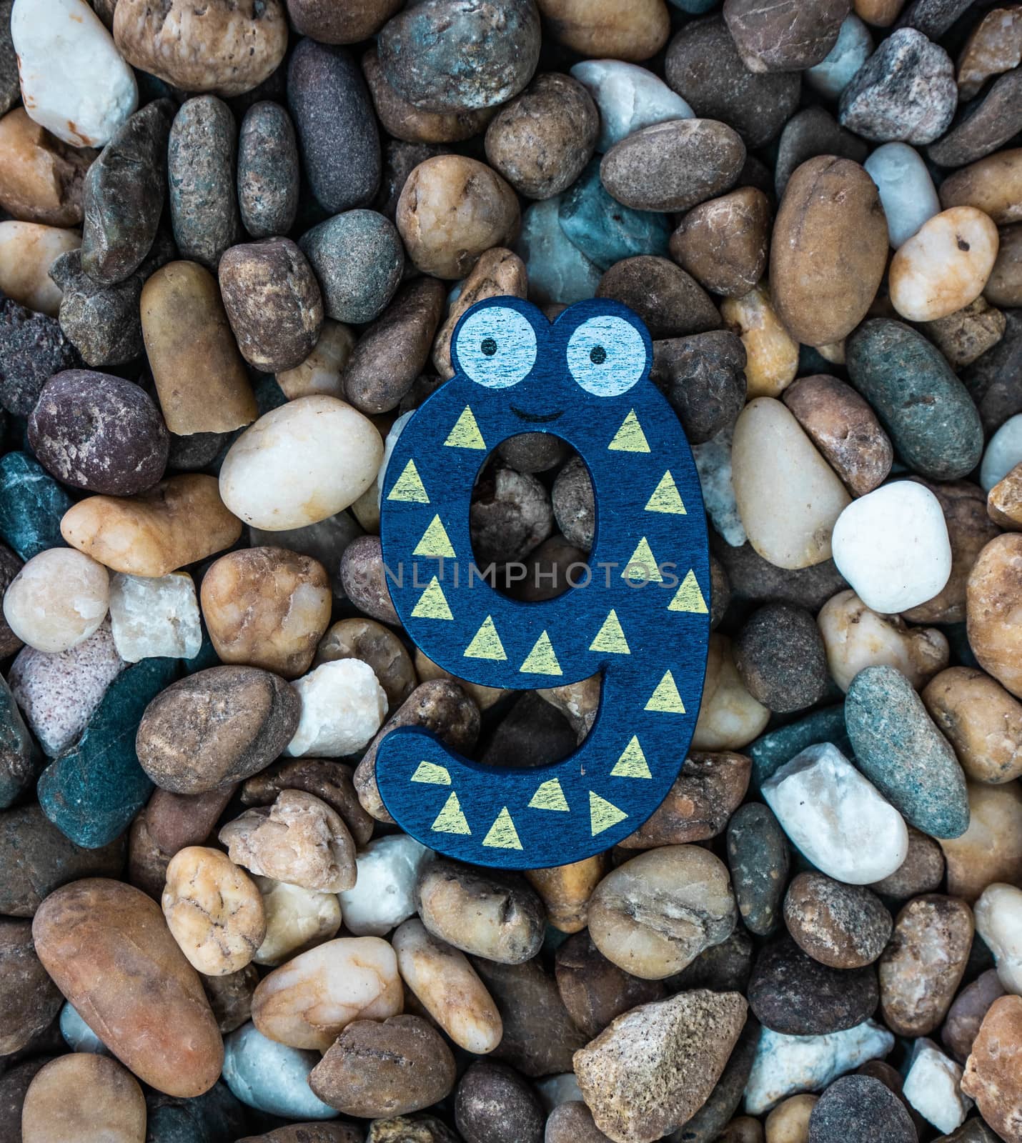Pebbles pattern or small stones background in garden with colorful Arabic wooden numbers; 9. Concept of new year and textured.