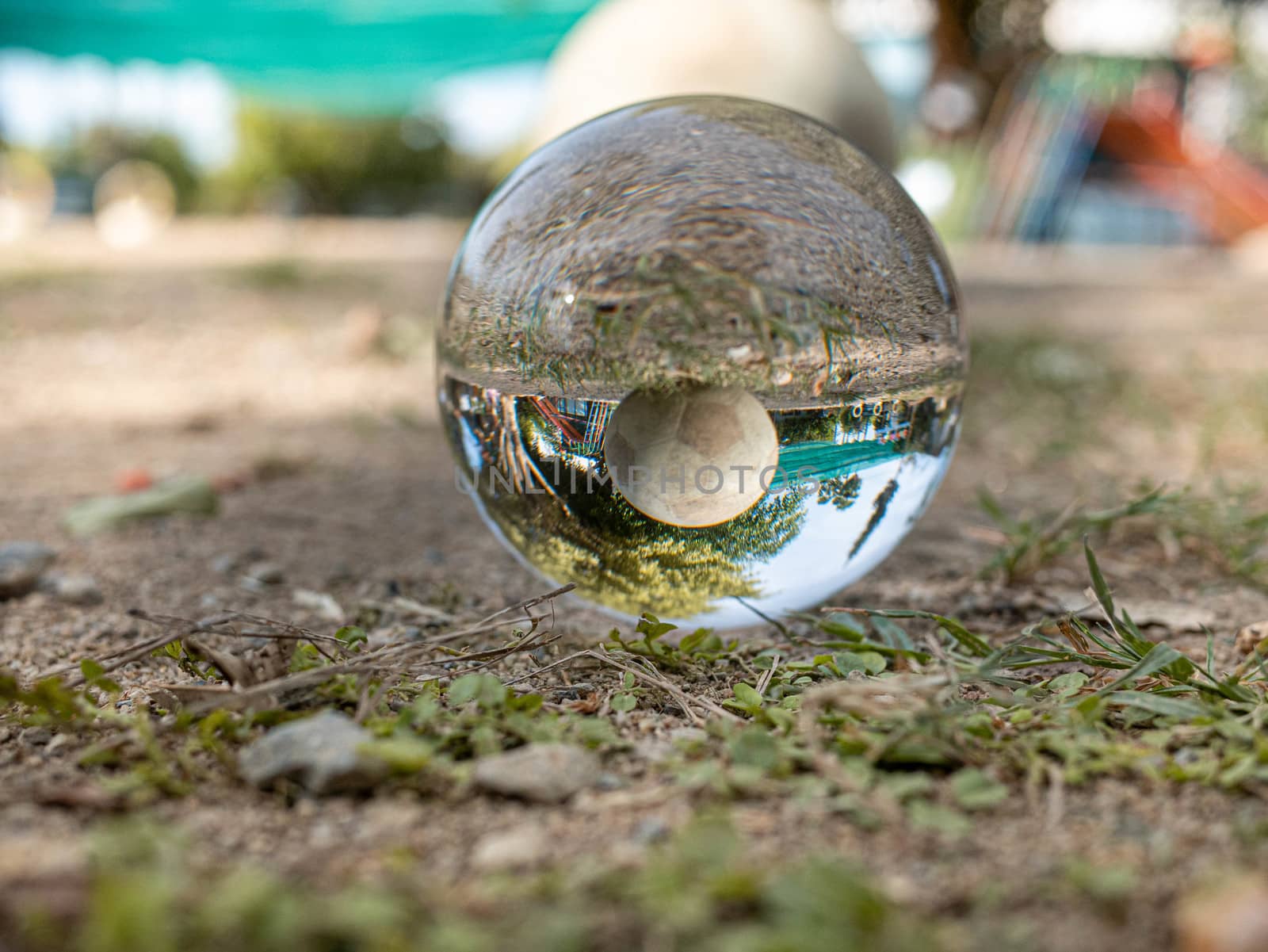 Crystal glass ball sphere place on ground and revealing the inner ball on blurred background.