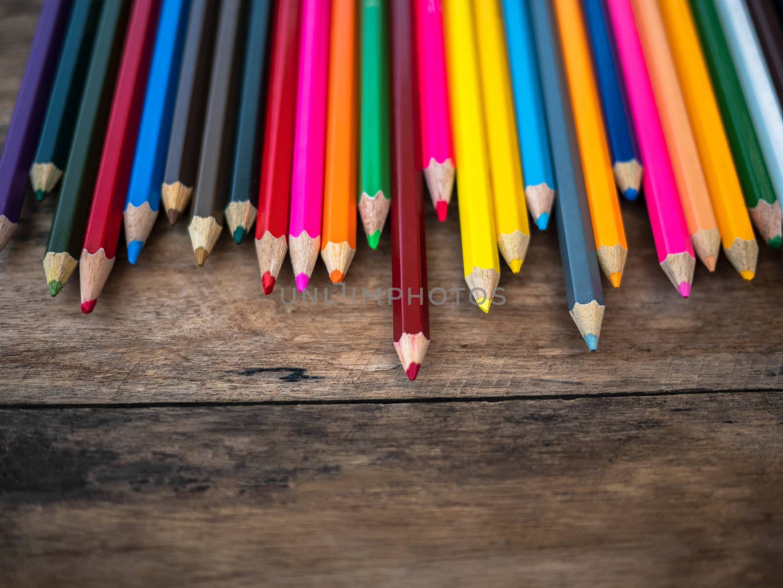 Color pencils place on wooden background with copy place for your text. by TEERASAK