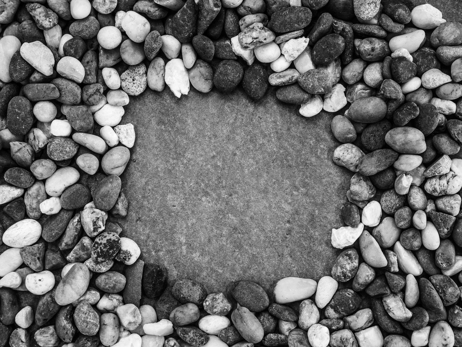 Pebbles pattern or small stones background in garden with copy space for your text. Black and white picture.