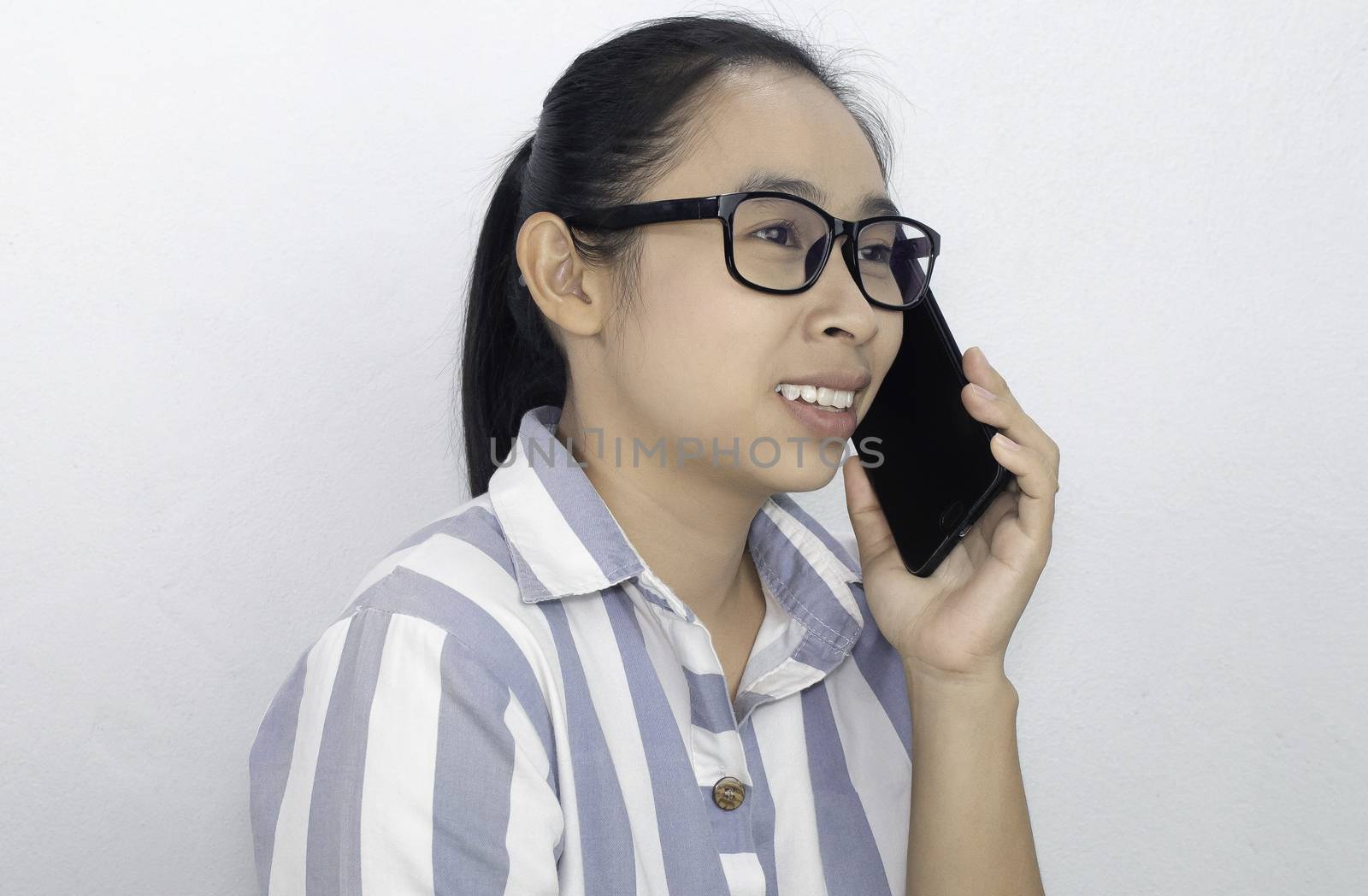 Cheerful Business Asian young woman talking on the phone over white background, Happy and smiling face. by TEERASAK