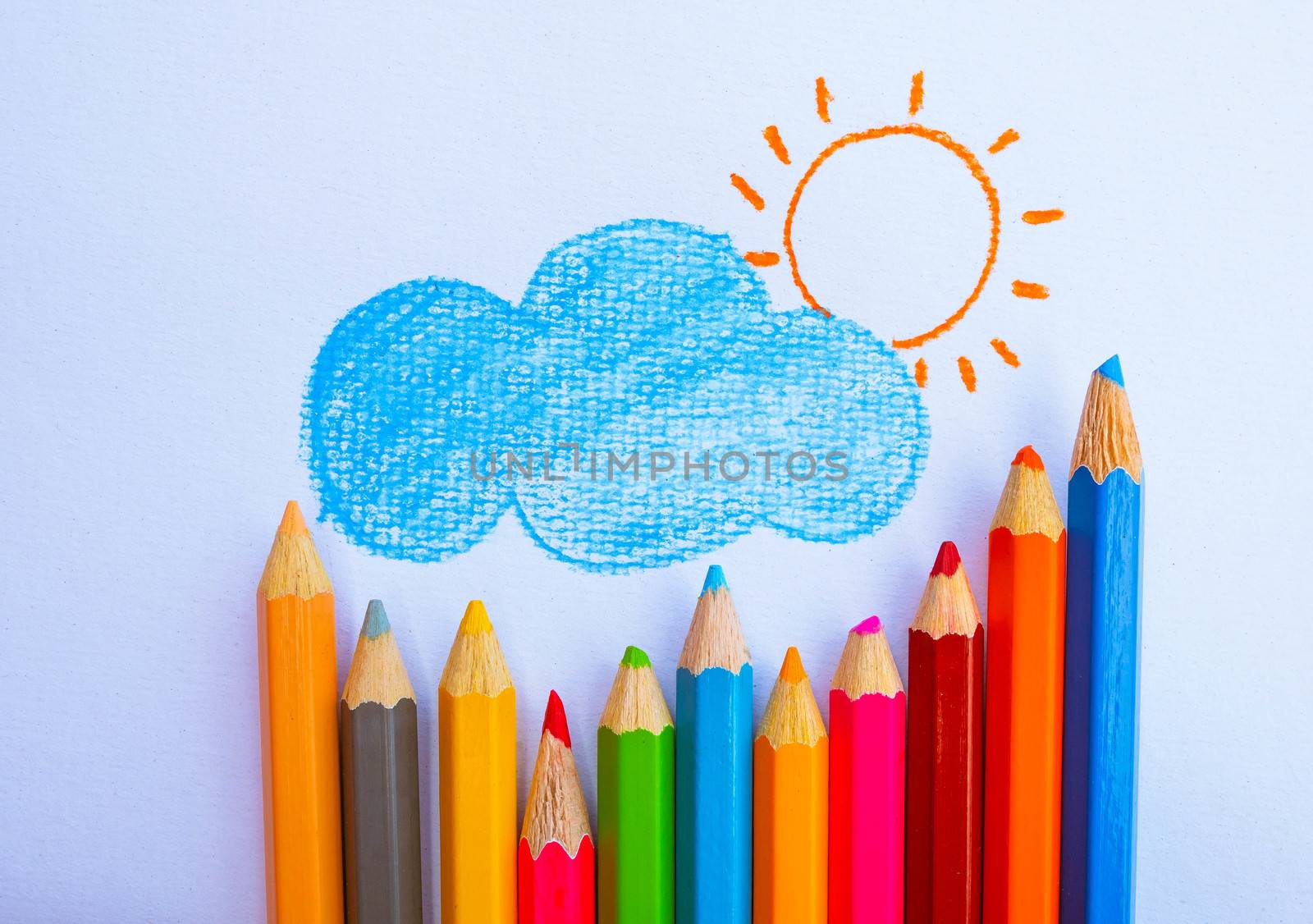 Color pencils place on white paper background with Clouds, rain and sun paintings. Education concept.