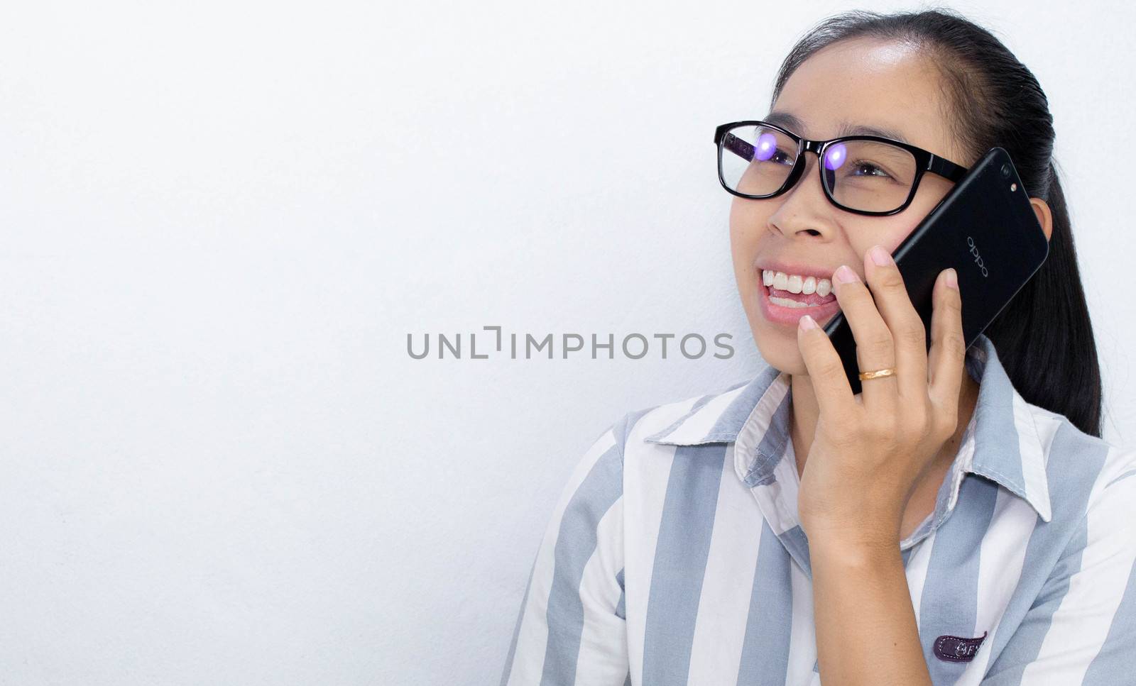 Cheerful Business Asian young woman talking on the phone over white background, Happy and smiling face. by TEERASAK