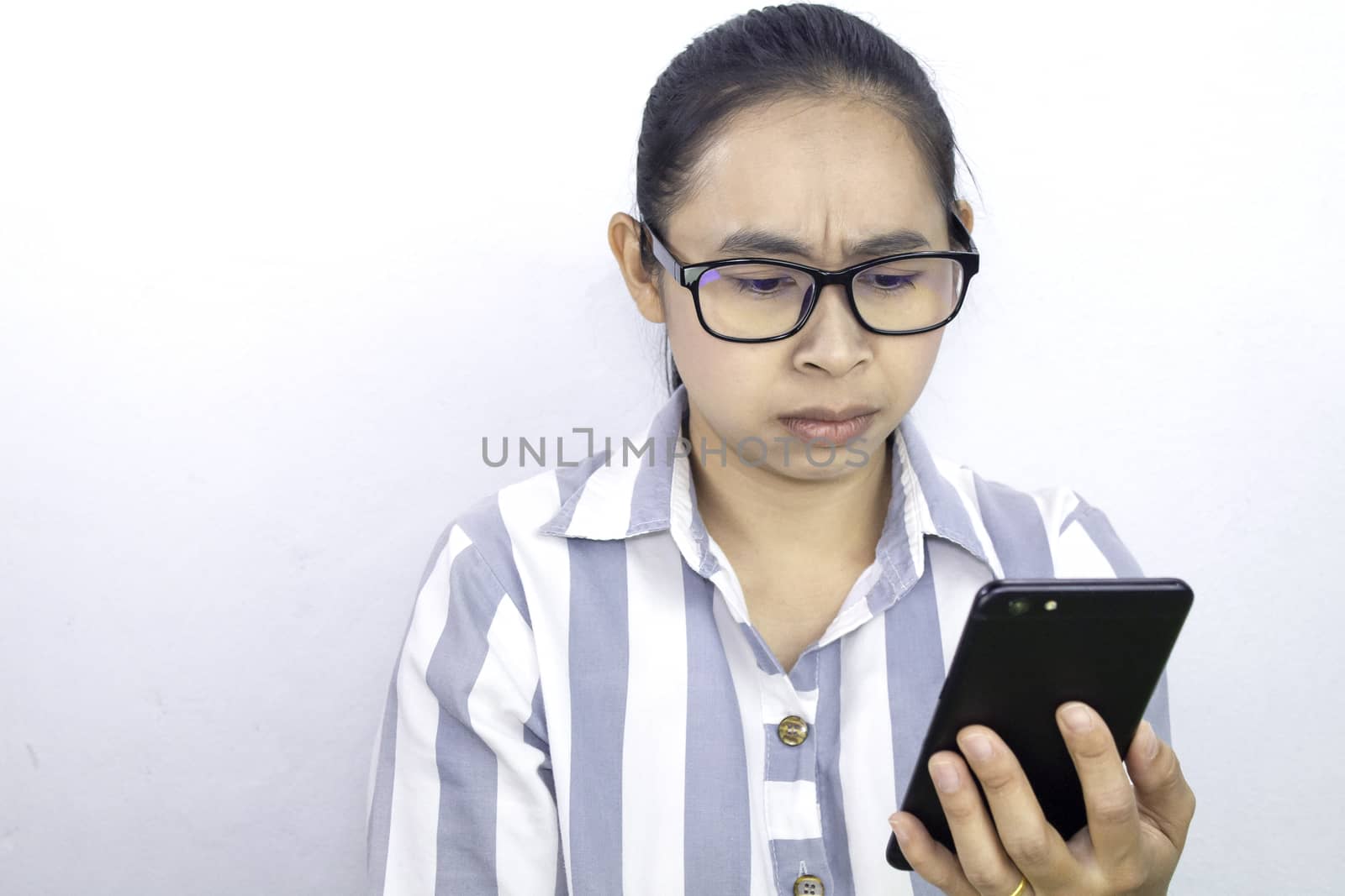 Confidenced business Asian young woman using smartphone over white background, Serious face.
