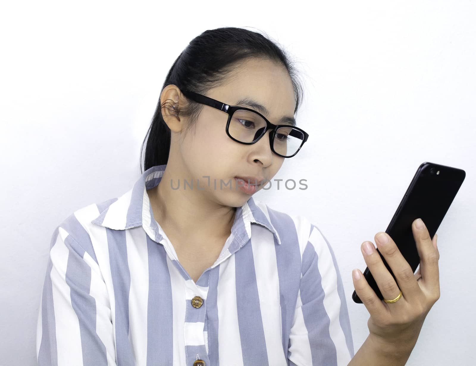 Confidenced business Asian young woman using smartphone over white background, Serious face.