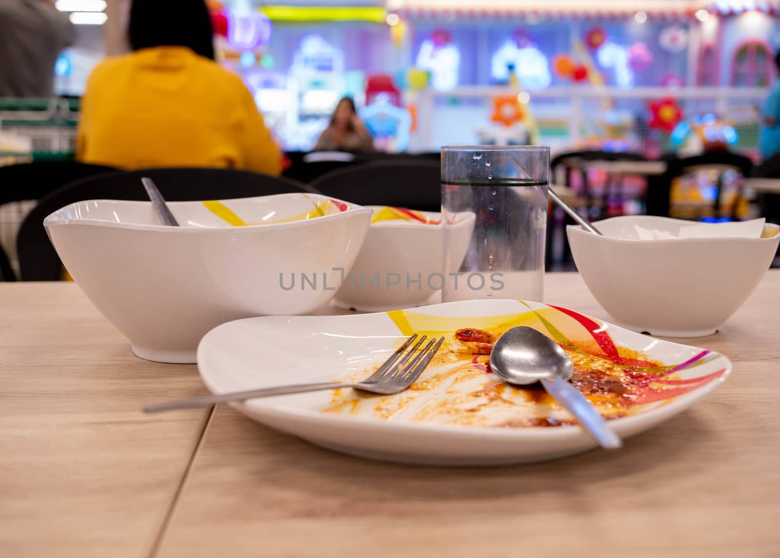 Dirty dishes on the table after lunch at food court in the mall. Dish ready for washing. by TEERASAK