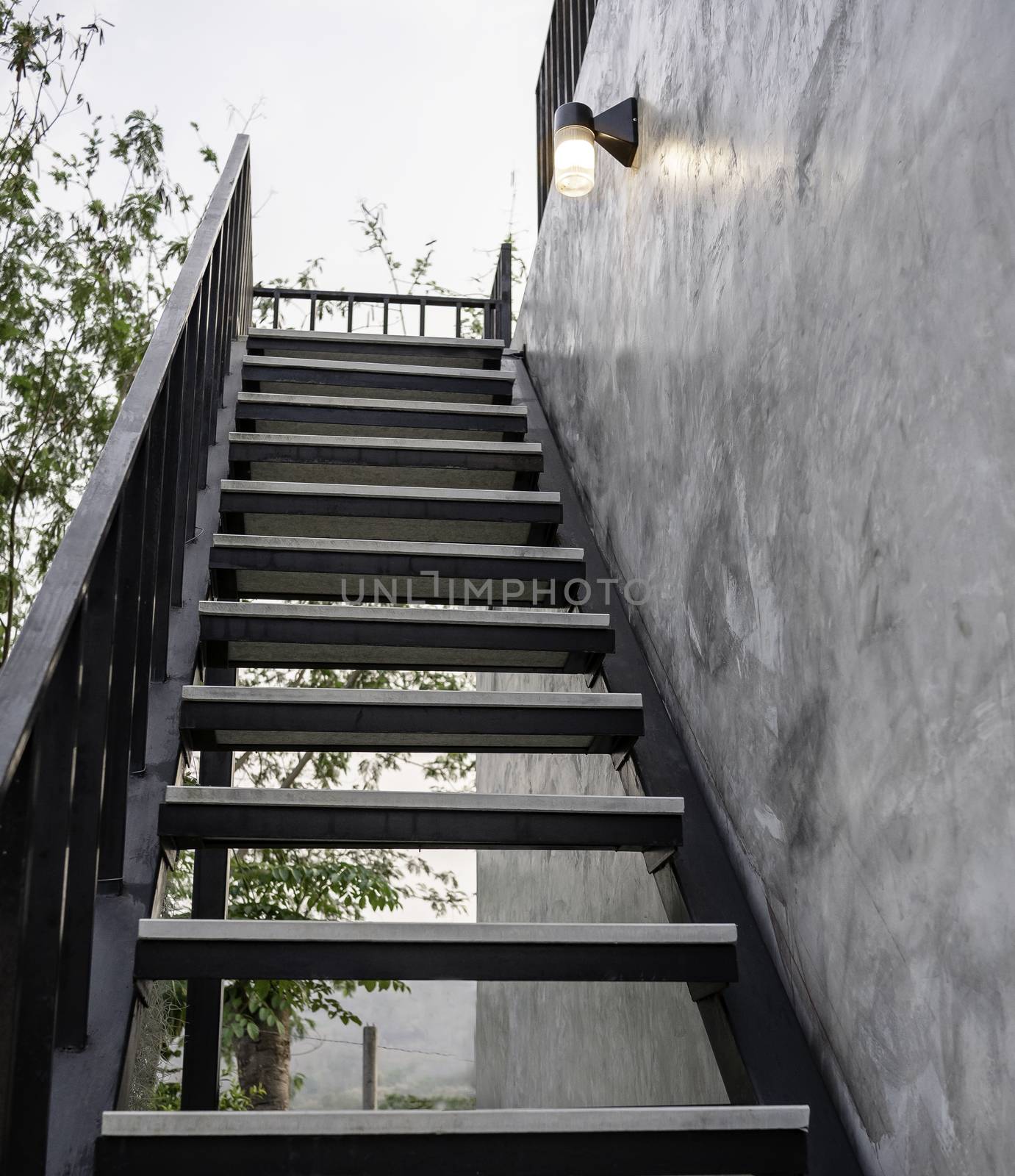 Stainless steel stairs outside the building with concrete wall.