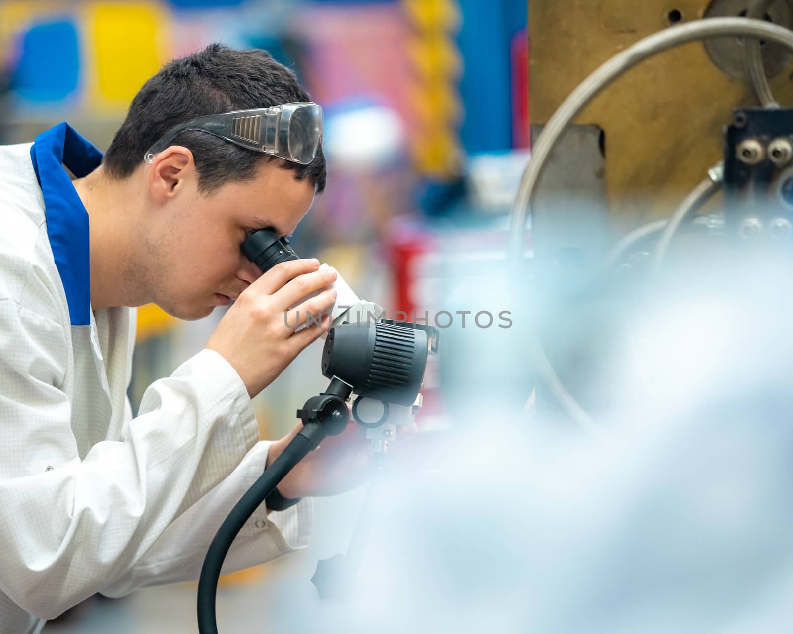 the engineer checks the correct setting of the metal mold for castings in the factory using a microscope by Edophoto