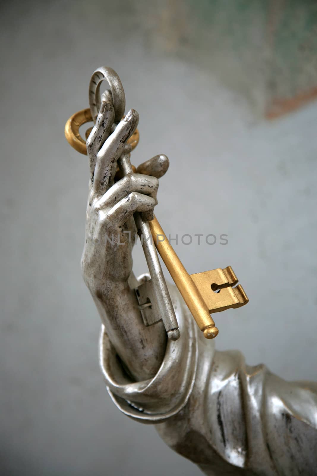 Hand of a figurine holding golden key