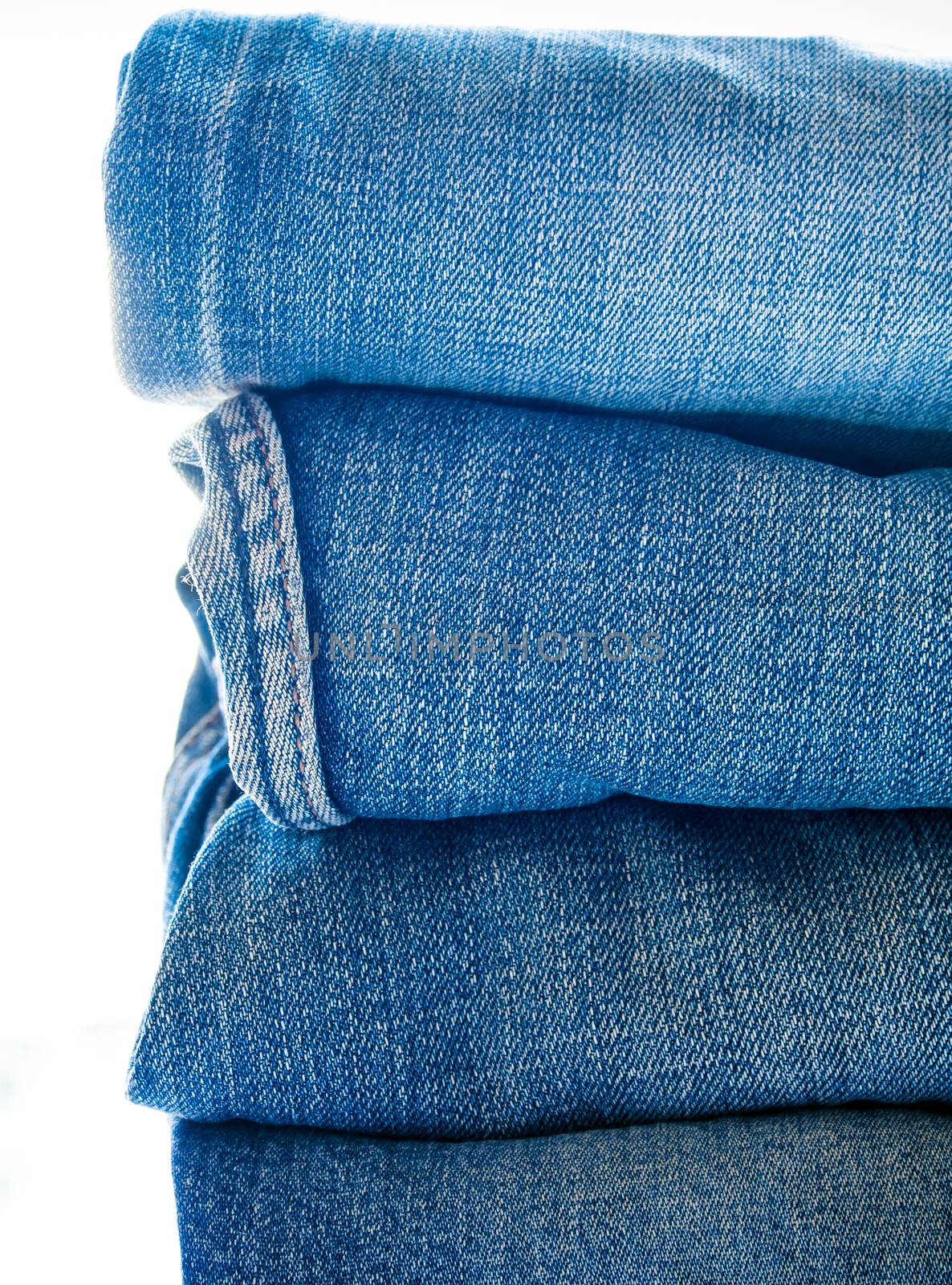 Pile of different blue jeans, fabric texture