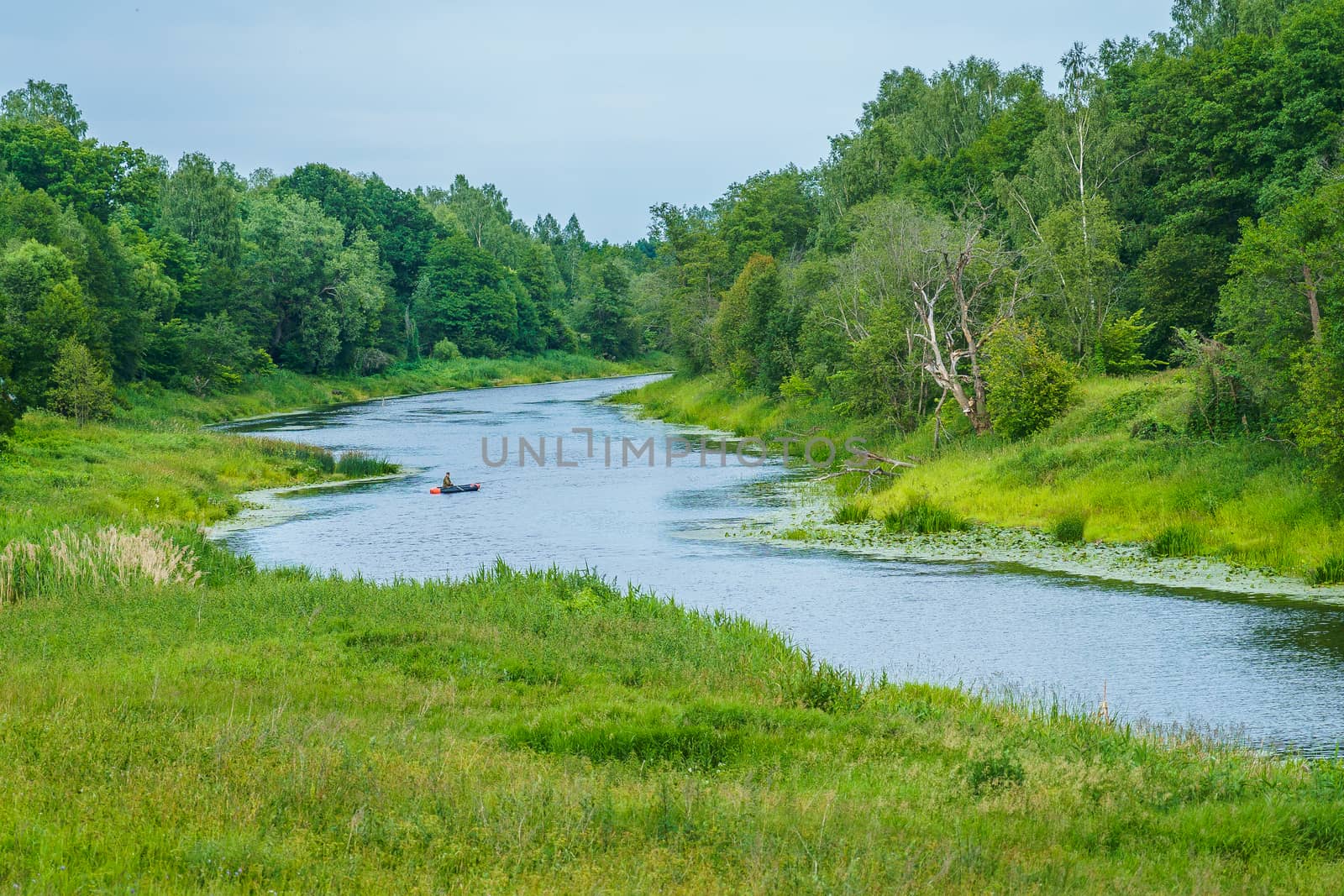 river among the green banks and the fisherman on a boat by VADIM