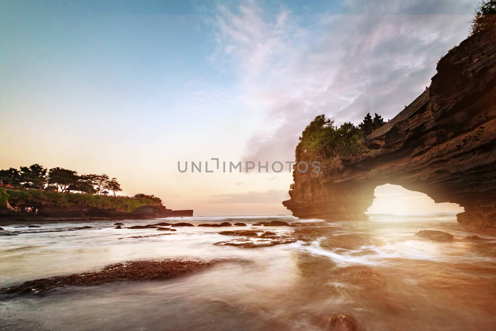 Sunset near famous tourist landmark of Bali island - Tanah Lot & Batu Bolong temple. Long exposure effect, Bali Indonesia. Tropical nature landscape of Indonesia, Bali.