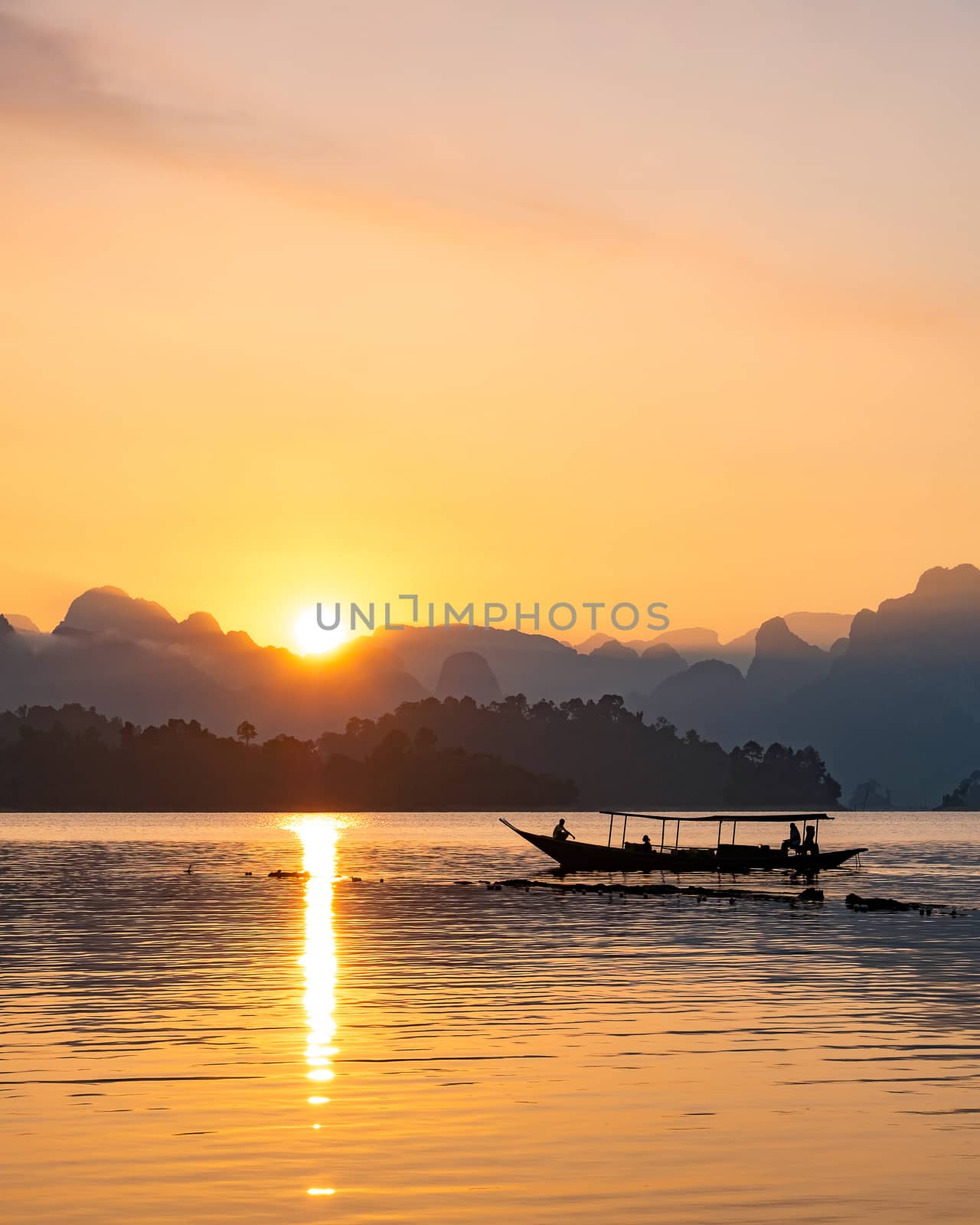 silhouette image of a  boat sailing in a dam in southern of Thailand in the morning. by Tanarch