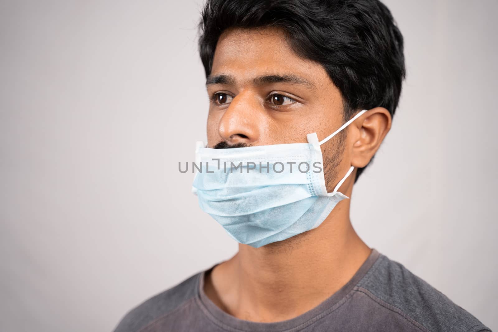 young man wearing medical mask below nose - concept showing of improper way of using face masks during coronavirus or covid-19 crisis. by lakshmiprasad.maski@gmai.com