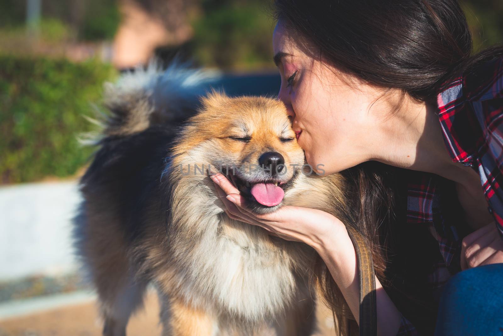 woman kissing dog with copy space for text