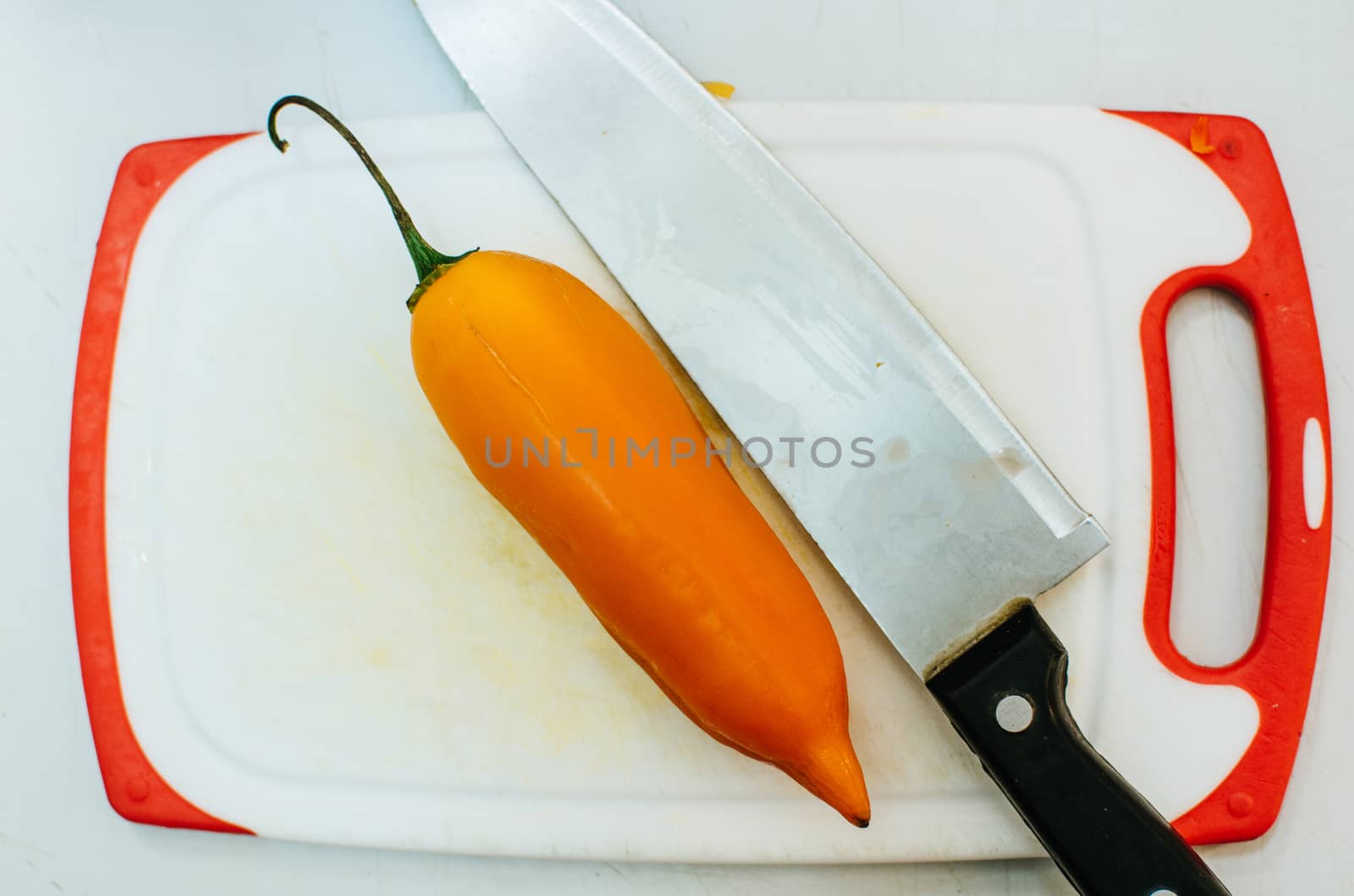 Chili pepper and a knife on a chopping board