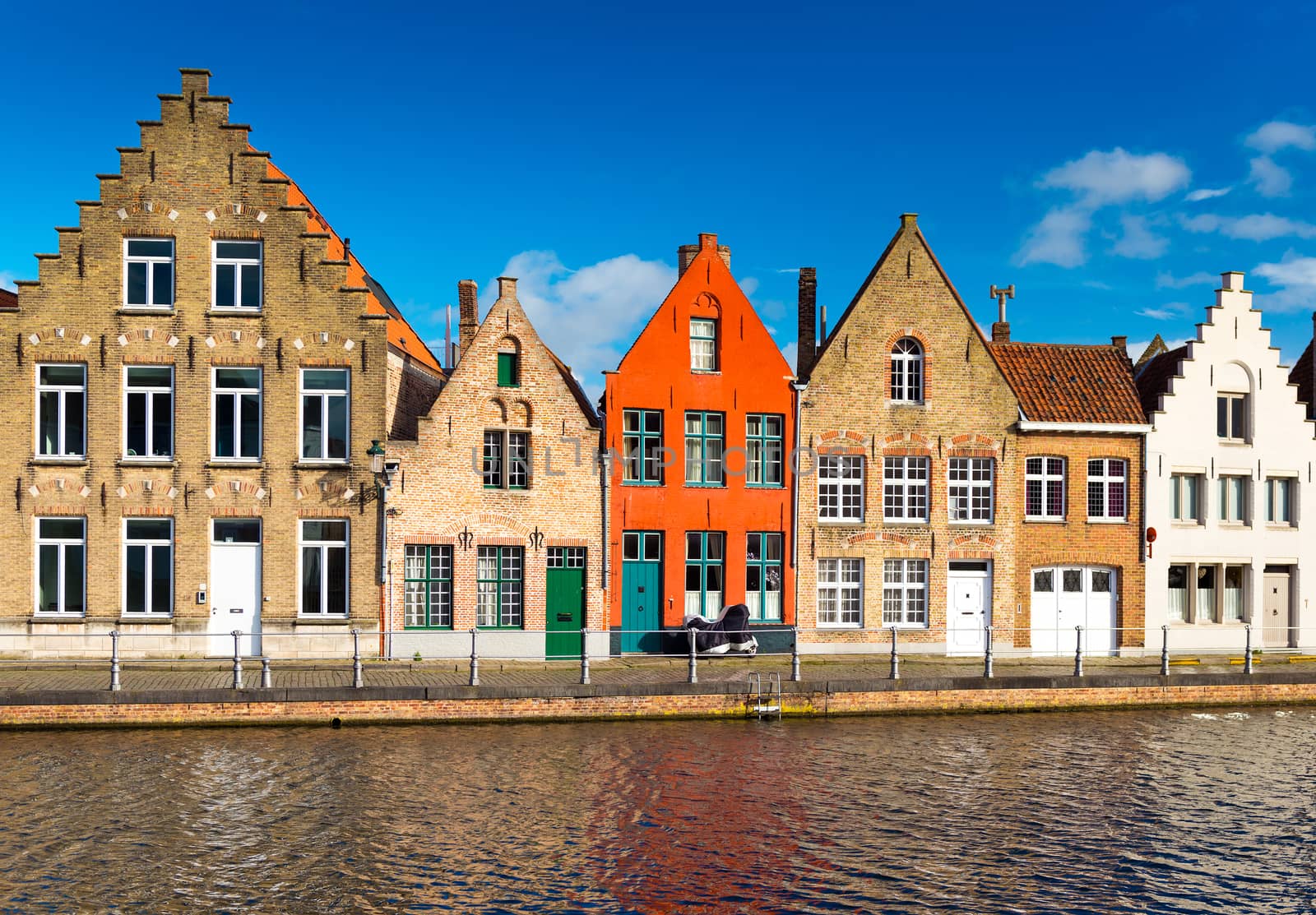 Brugge (Bruges), Belgium. Colored houses in the traditional architecture style and canal with water.
