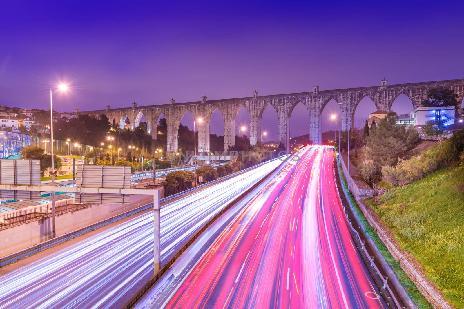 View of highway with car traffic and light trails. The Aguas Livres Aqueduct (Aqueduto das Águas Livres) in Lisbon, Portugal