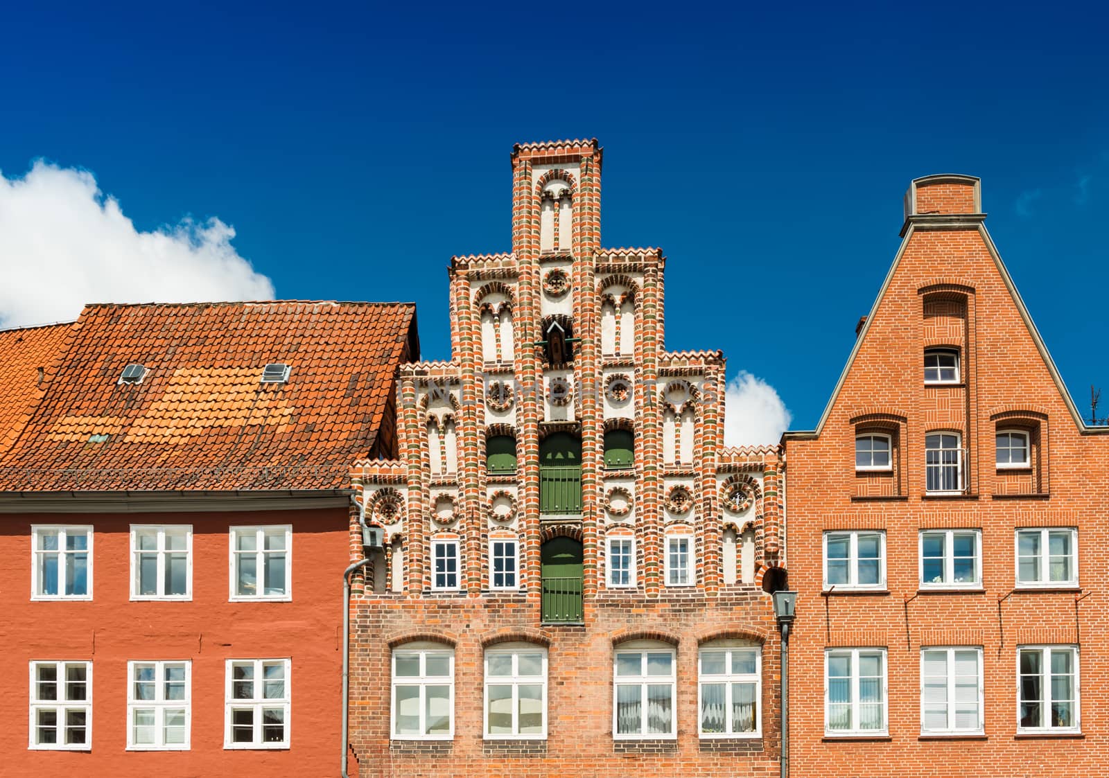 Facades of the old historical buildings made of red brick. Blue sky on the background. Luneburg, Germany