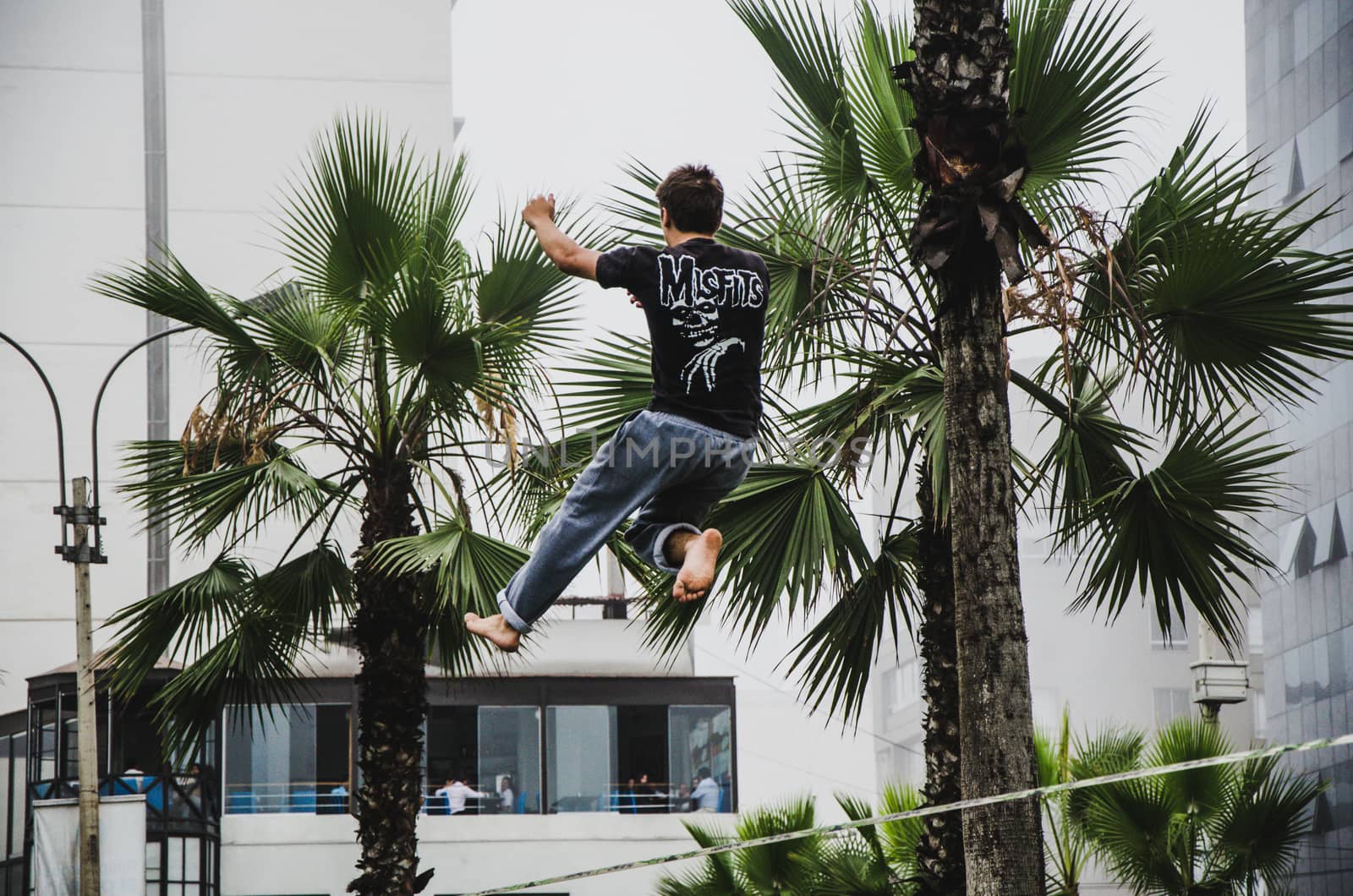 Man on rope jumping and doing balance