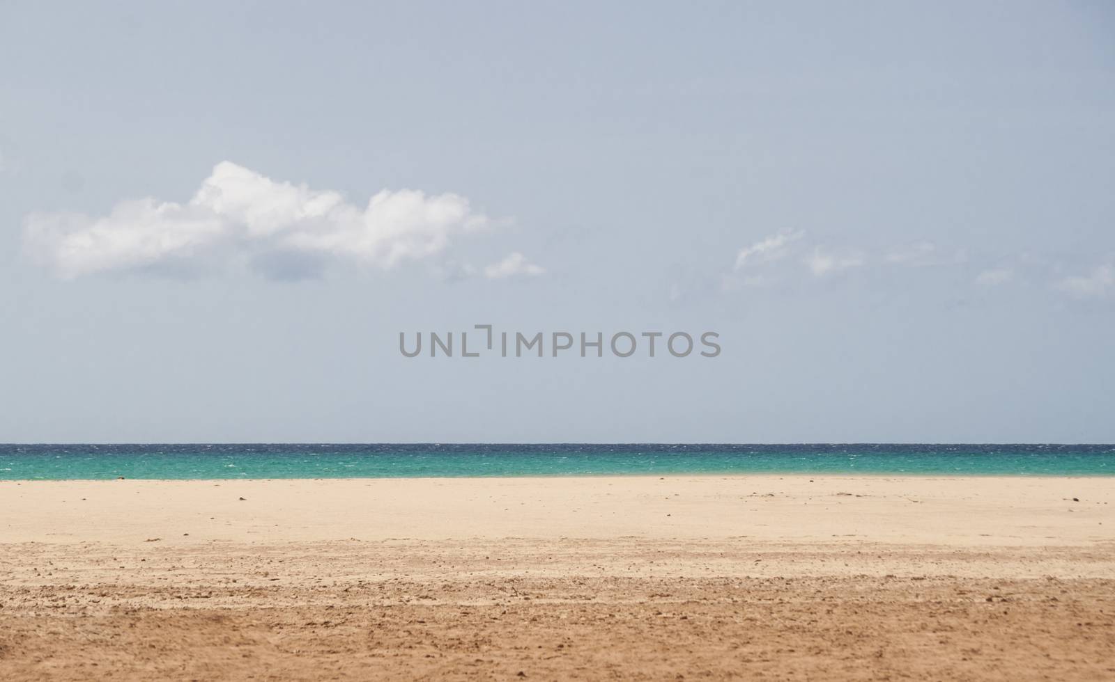 Open beach with blue water and sky. Many copy space available.